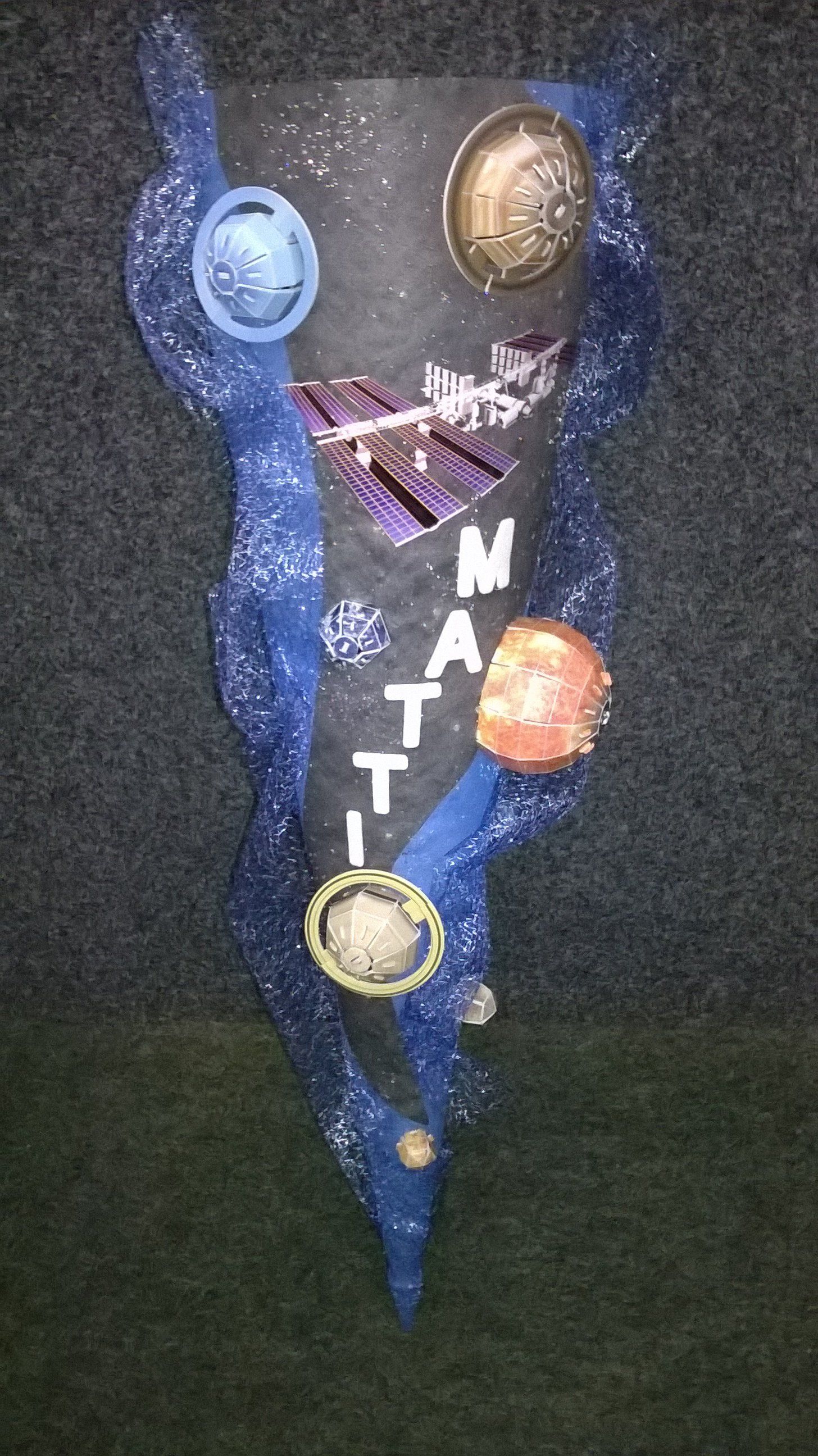 Auf einem Tisch steht ein Kegel mit einem Galaxienmuster.