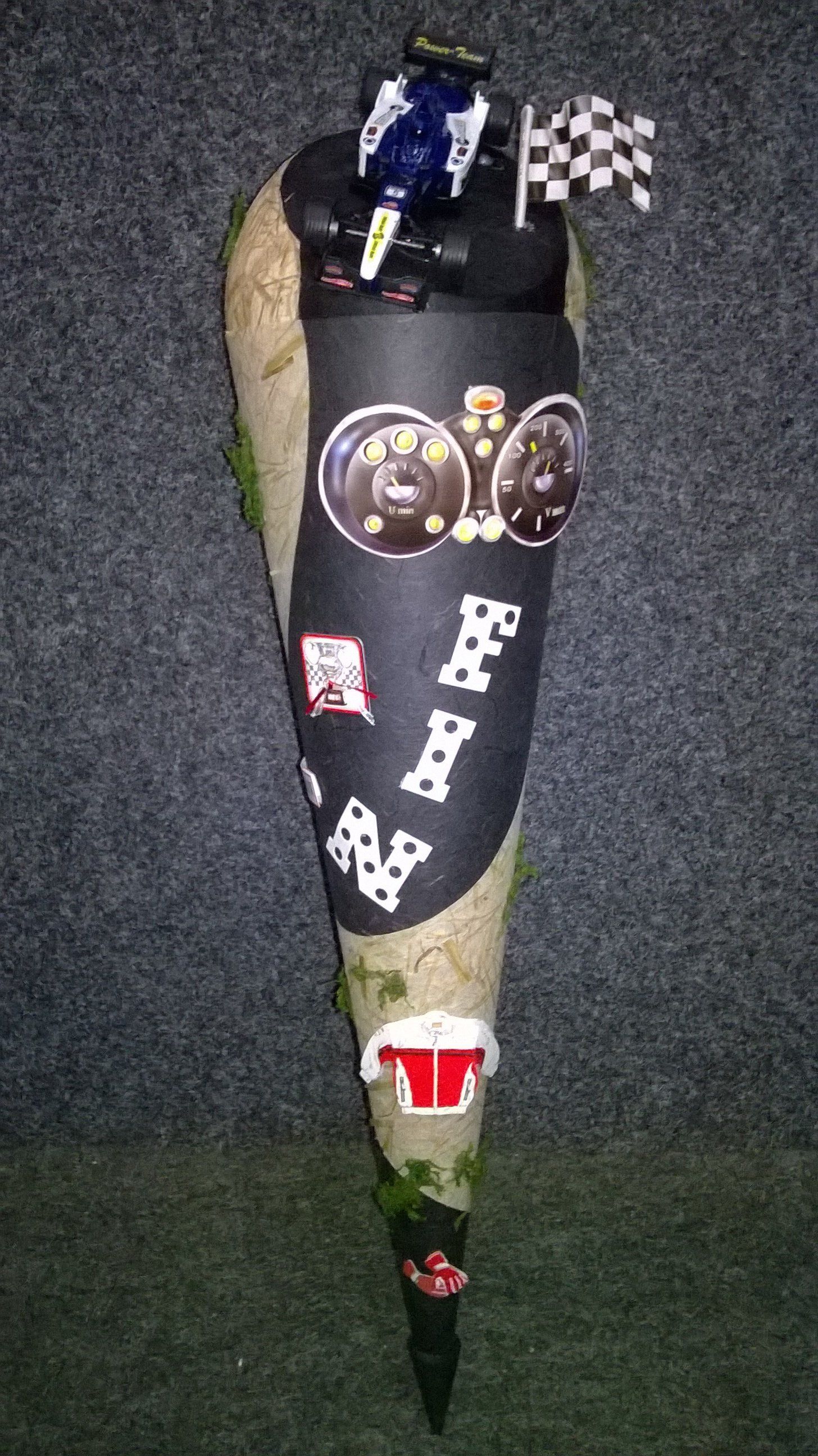 Ein schwarzer Kegel mit einem Rennauto darauf.