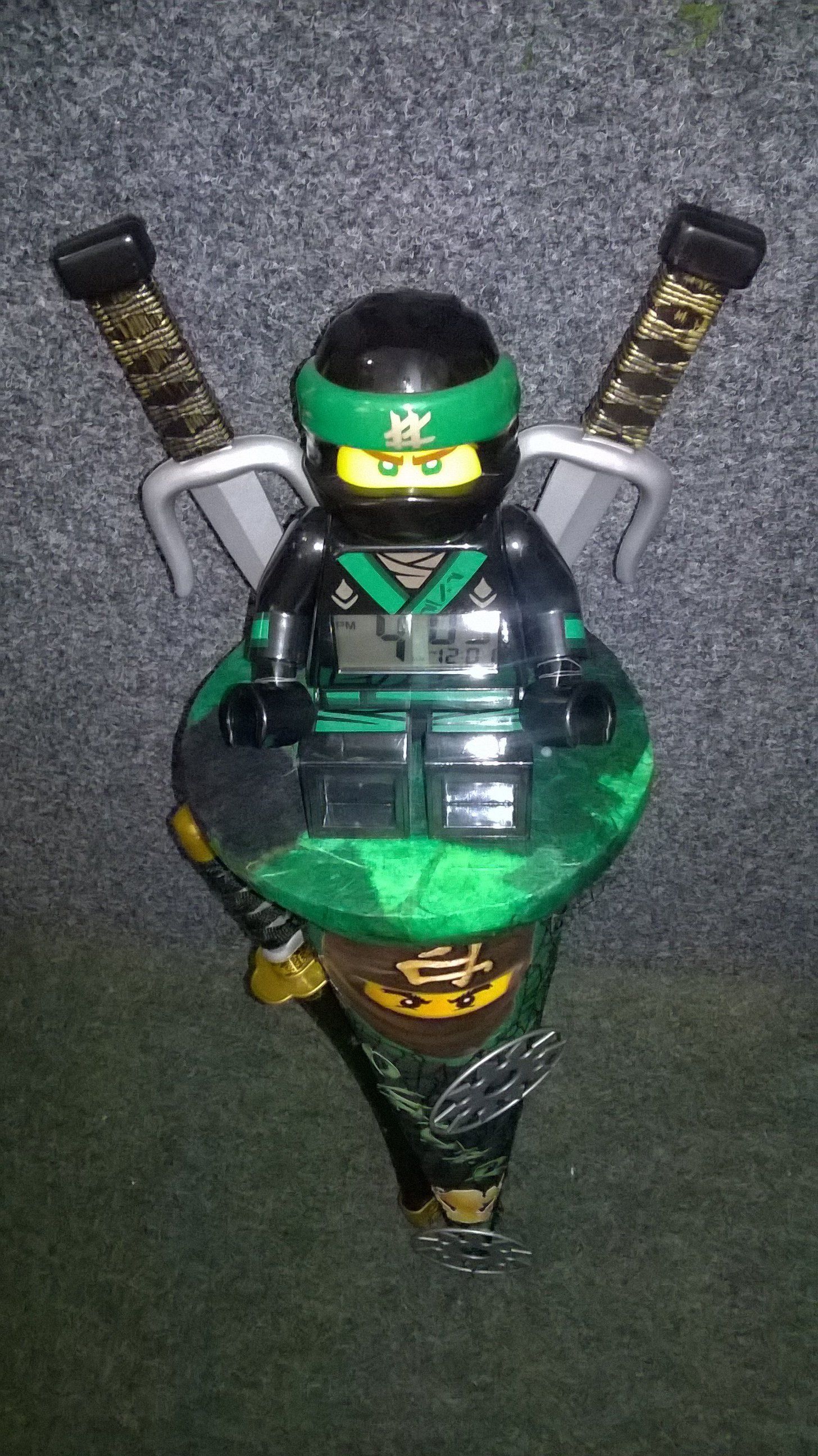 Eine Lego-Ninjago-Figur sitzt auf einem grünen Kreisel.
