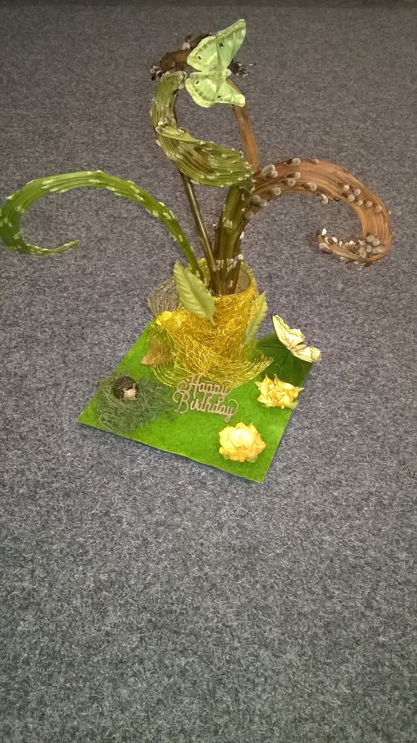 Auf einem Tisch steht eine Pflanzenskulptur.