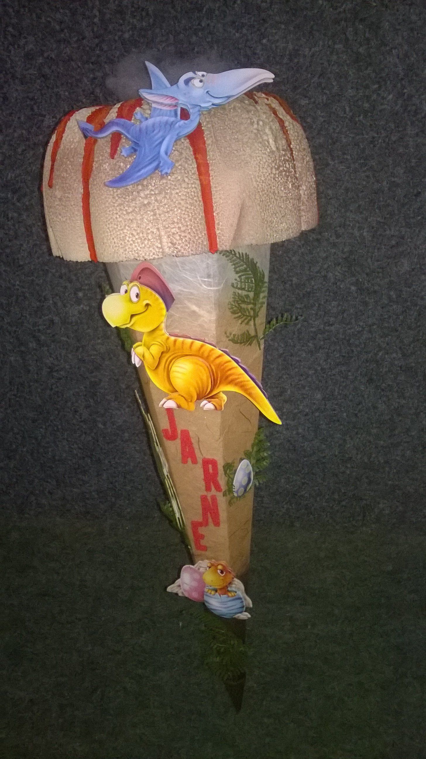 Eine Schultüte mit Dinosauriern obendrauf.