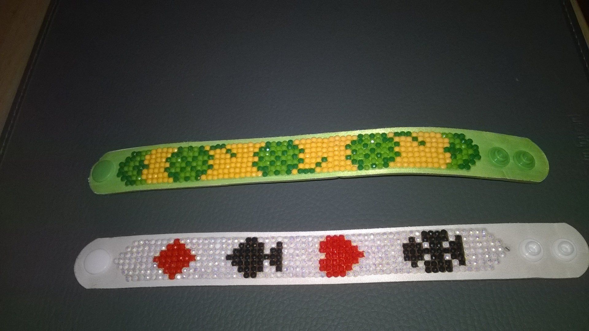 Zwei Perlenarmbänder liegen auf einem Tisch