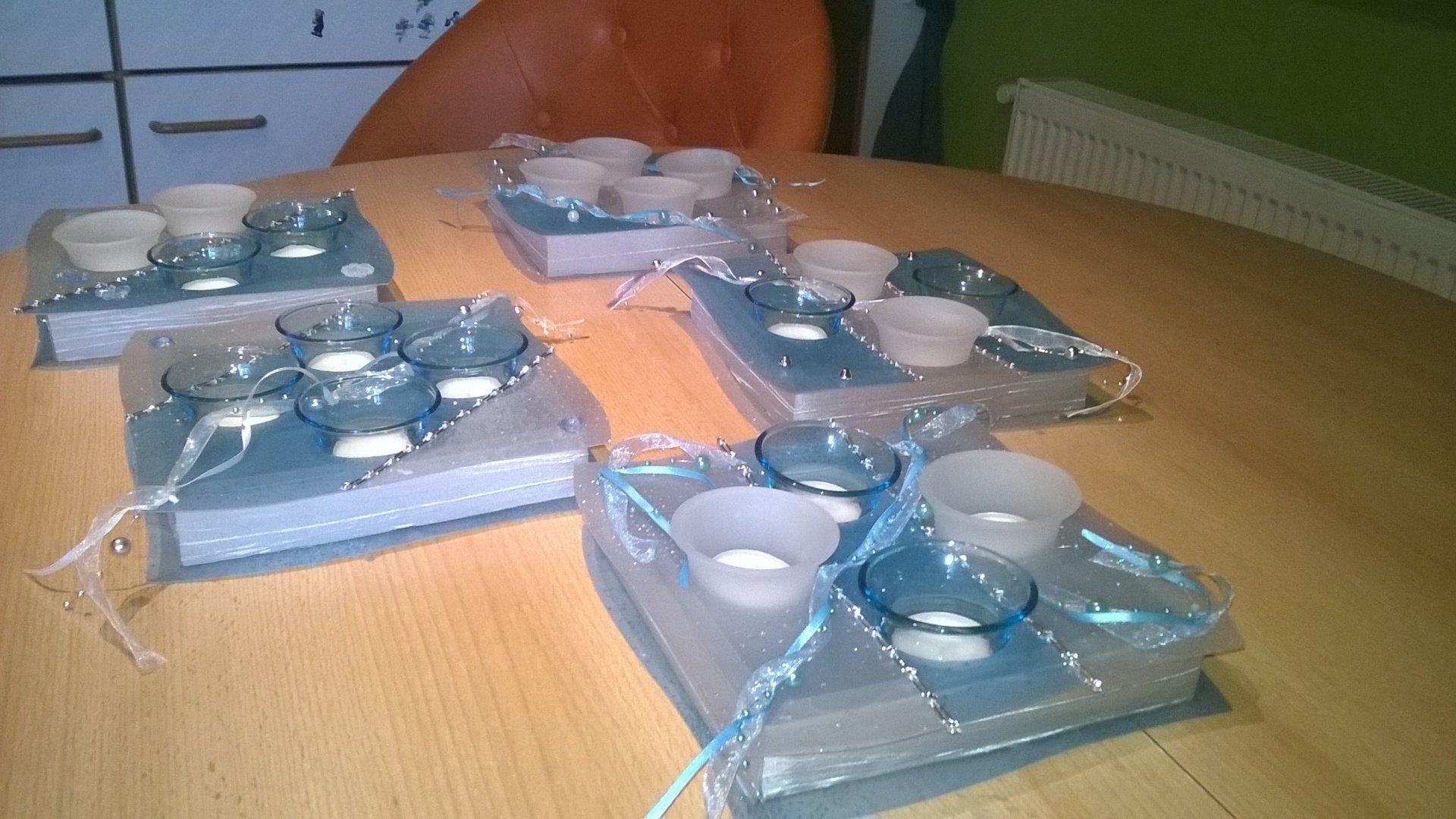 Vier Kerzenständer stehen auf einem Holztisch