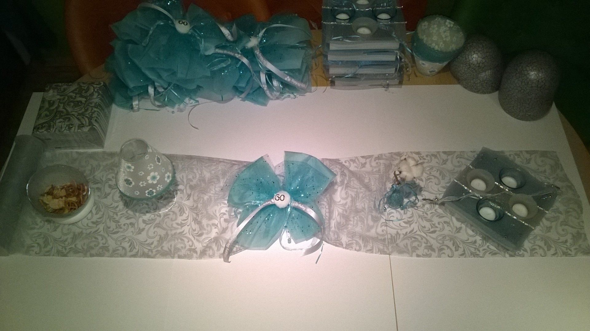 Ein Tisch mit einem Tischläufer, Kerzen und anderen Dekorationen.