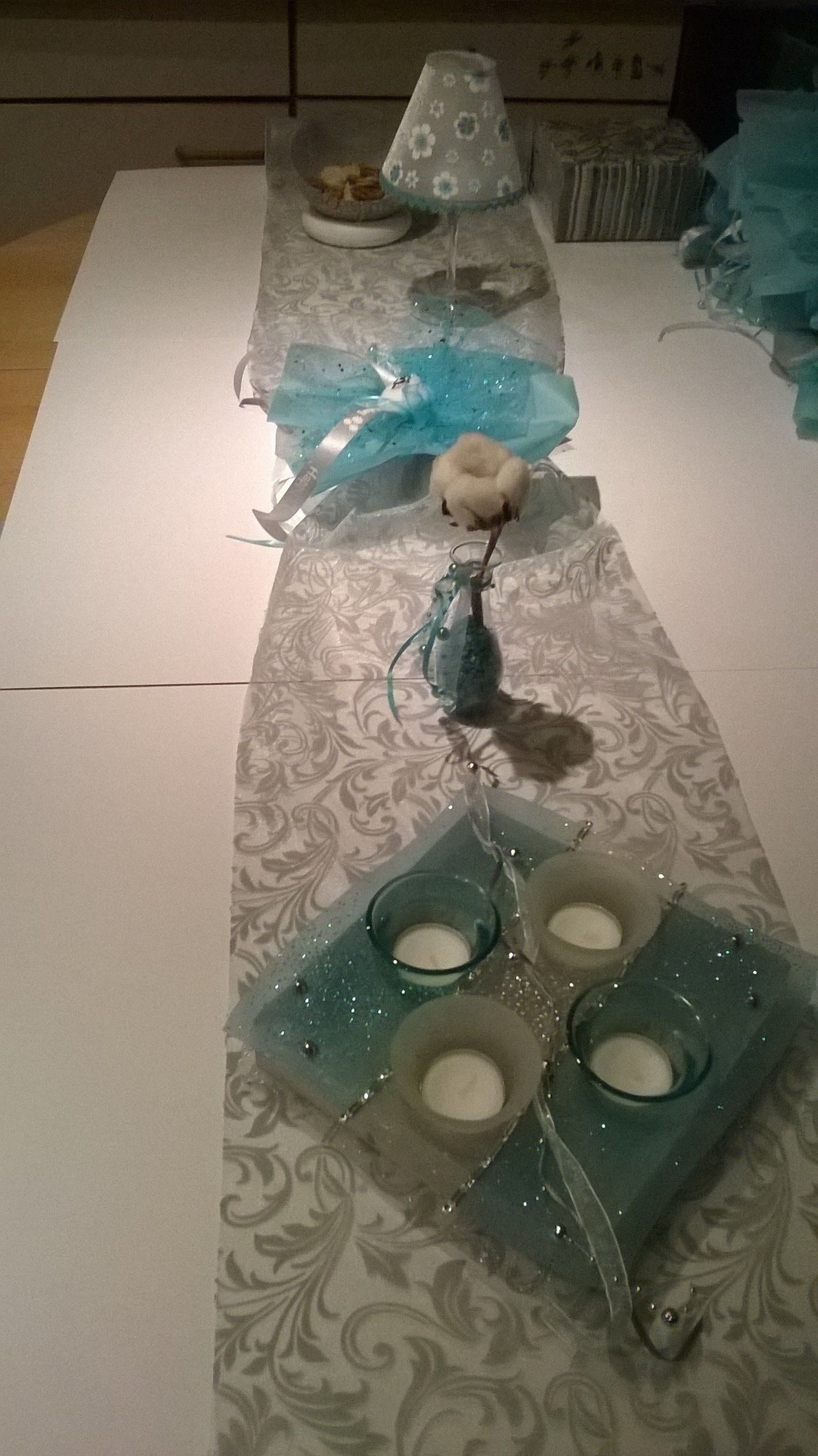 Ein Tisch mit einem Tischläufer und Kerzen darauf.