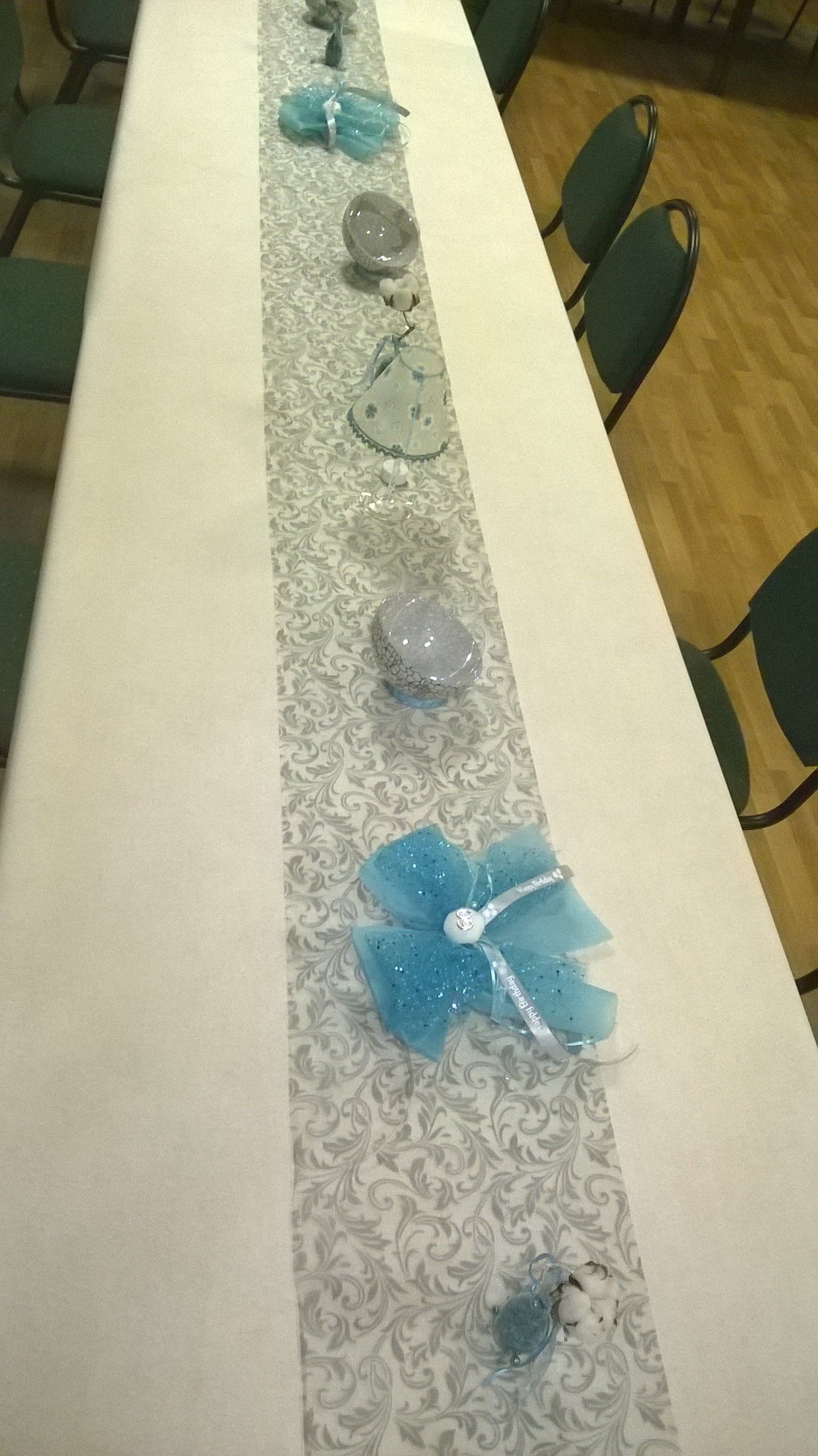 Ein langer Tisch mit einem Tischläufer und Kerzen darauf.