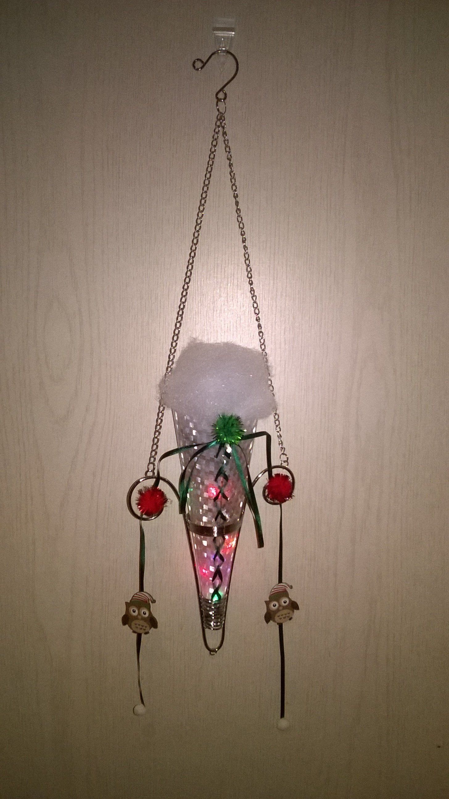 Eine Weihnachtsdekoration, die an einer Kette an einer Wand hängt