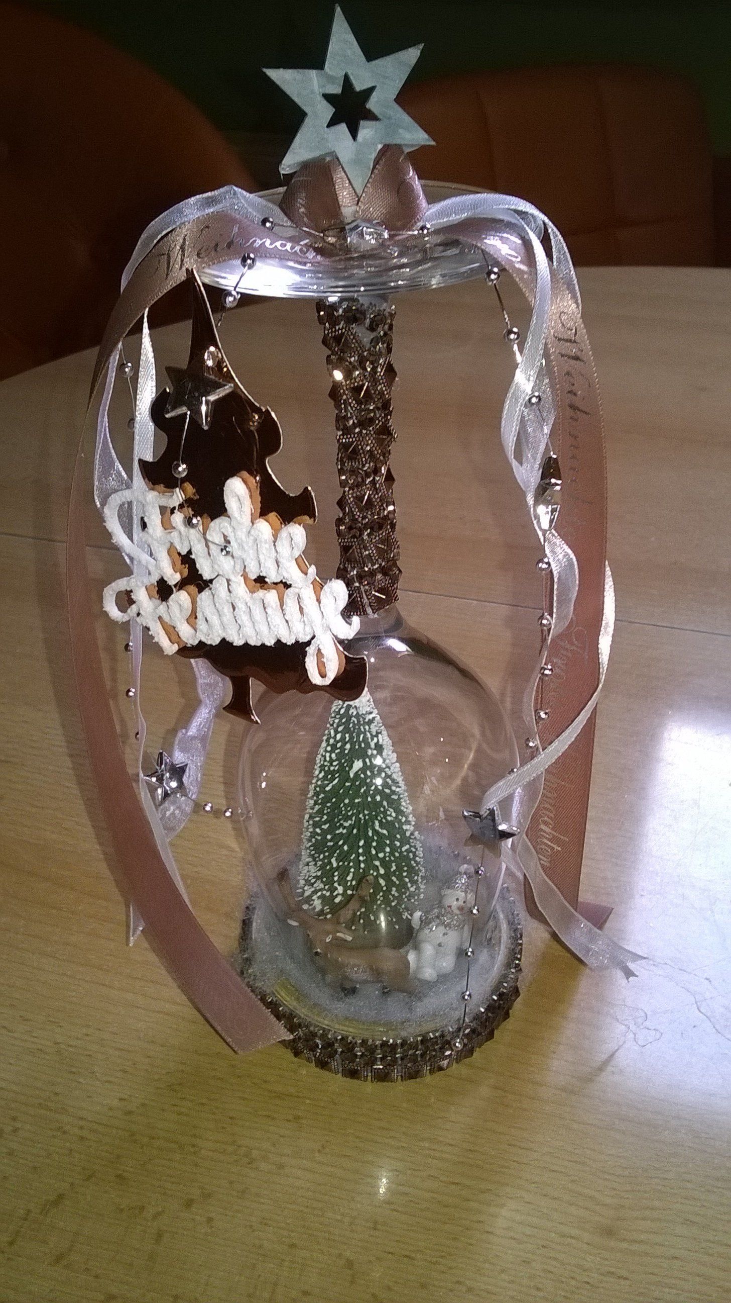 Auf einem Tisch steht ein Weihnachtsschmuck mit einem Weihnachtsbaum darin.