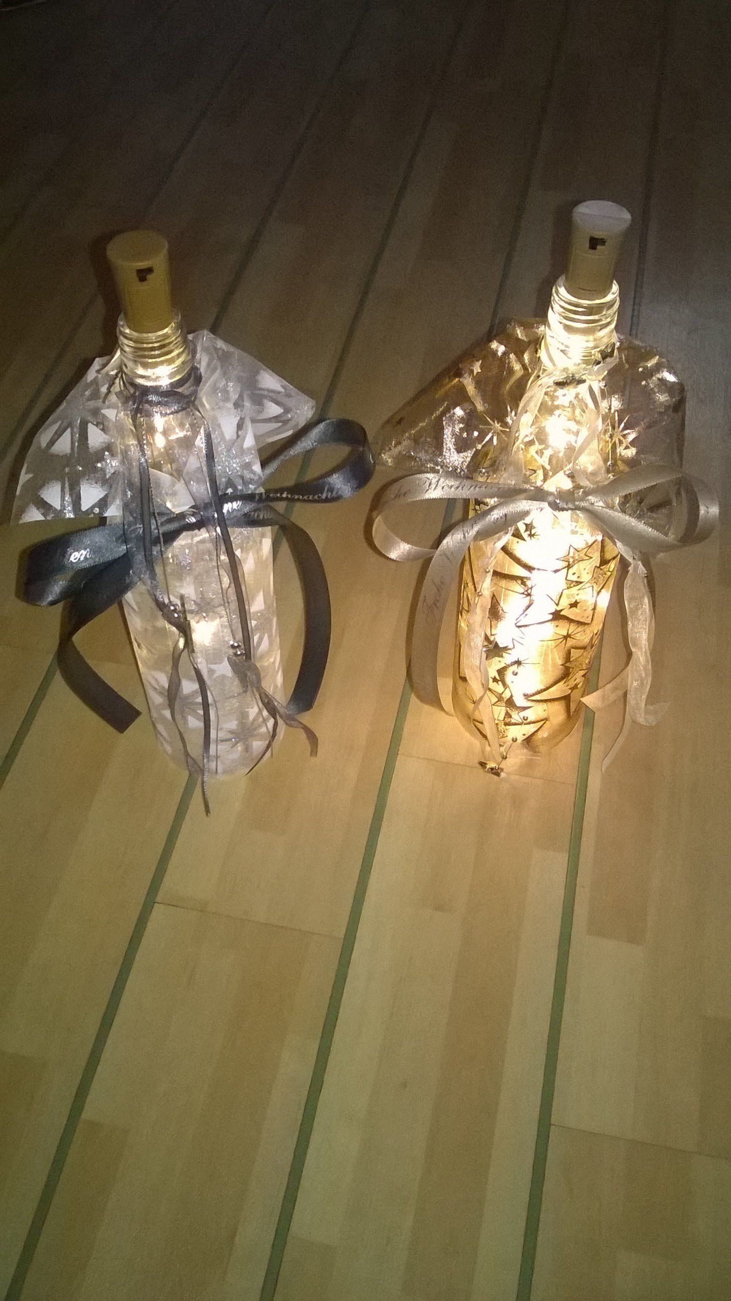 Zwei Weinflaschen stehen auf einem Holzboden.