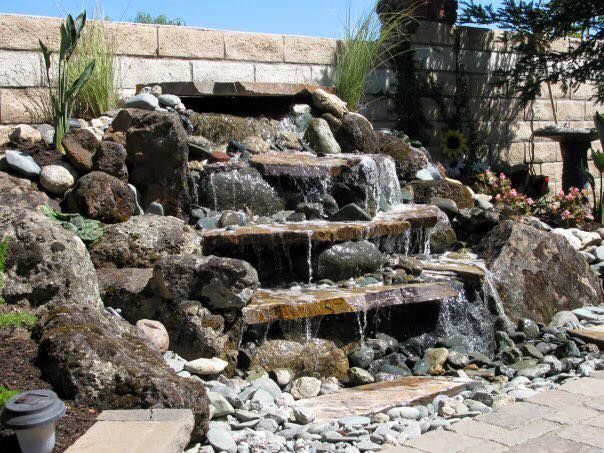A Waterfall Is Surrounded by Rocks and A Brick Wall | Redding, CA | Chase Design Landscape