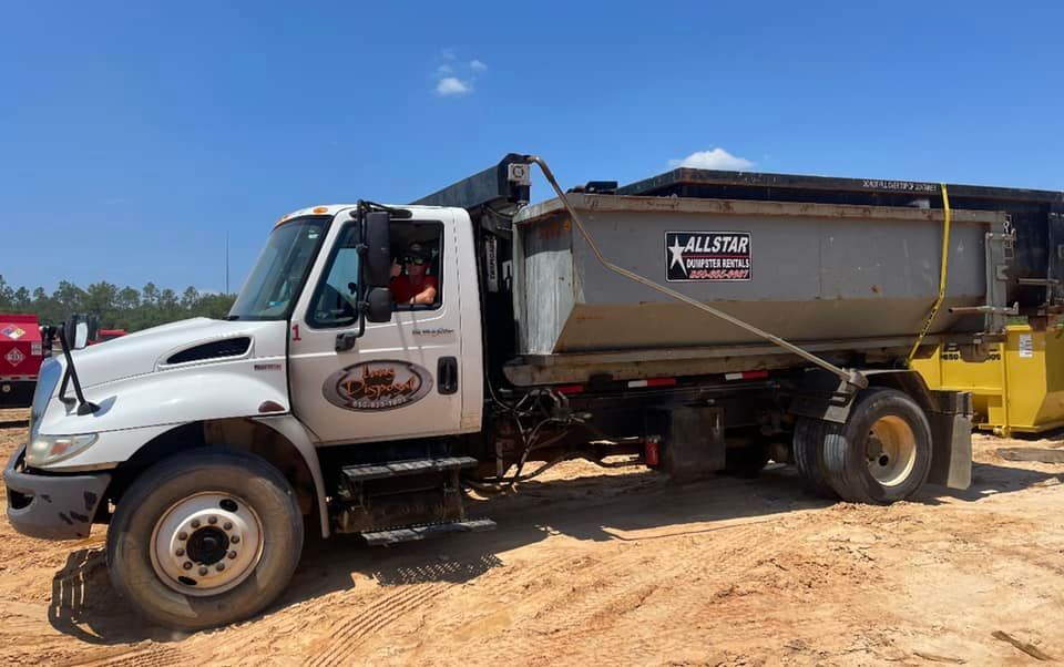 White dump truck with a silver bed parked on a dirt lot under a blue sky White dump truck with a silver bed parked on a dirt lot under a blue sky
