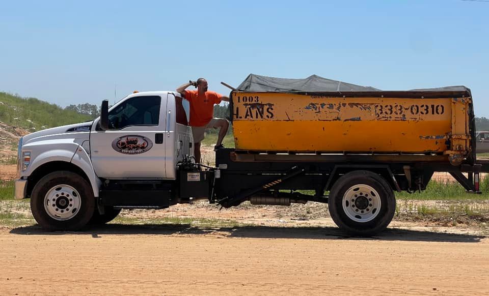 White utility truck with orange cargo bed parked on a dirt road in a rural area under a blue sky White utility truck with orange cargo bed parked on a dirt road in a rural area under a blue sky