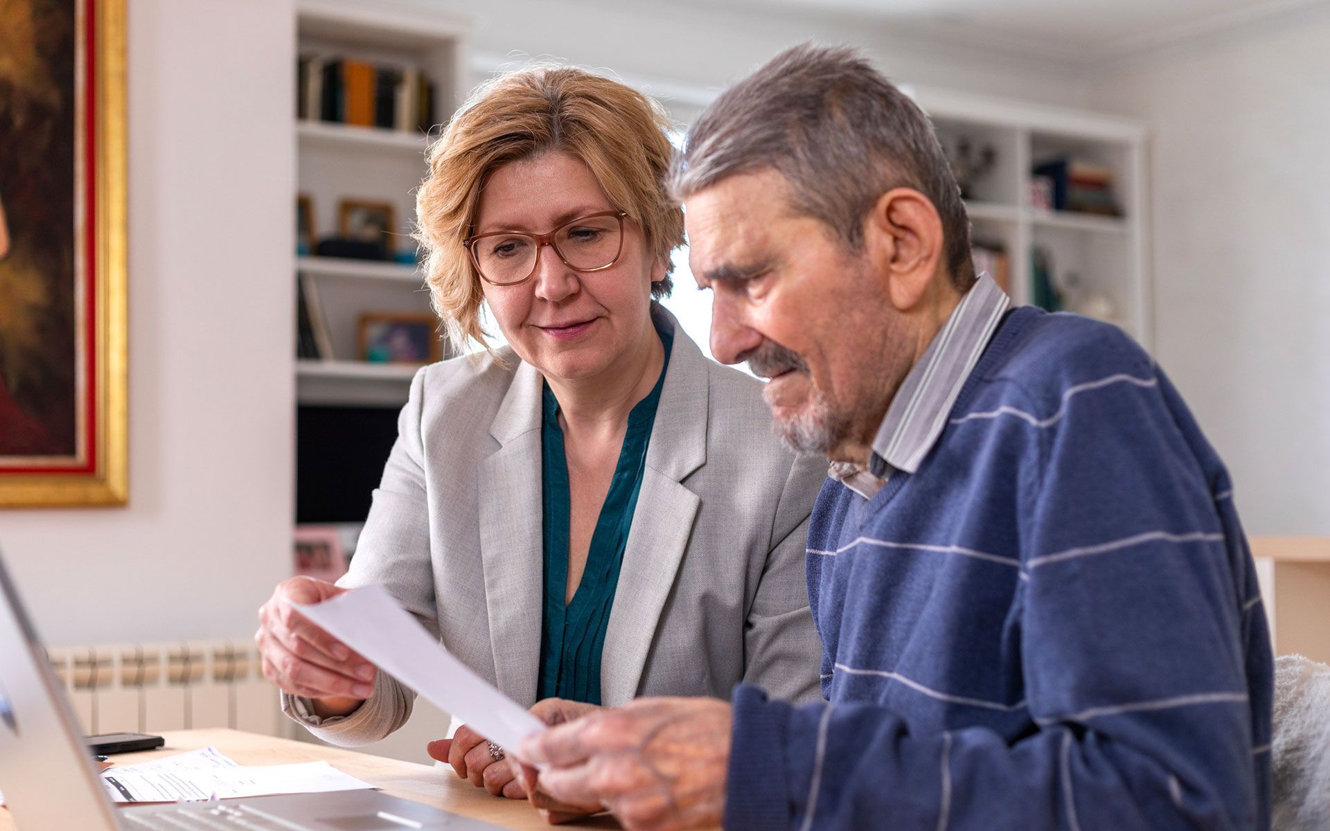 A woman and a man are looking at a laptop computer.