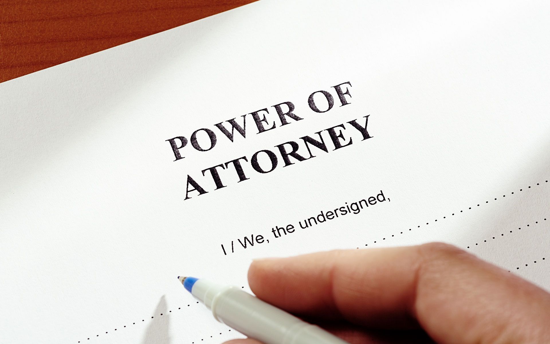 A person is writing a power of attorney on a piece of paper