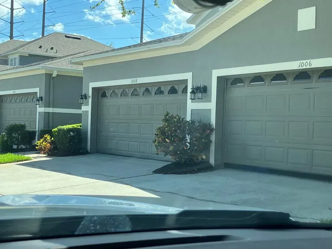 garage door installation apopka fl Gray townhomes with beige garage doors; front view.
