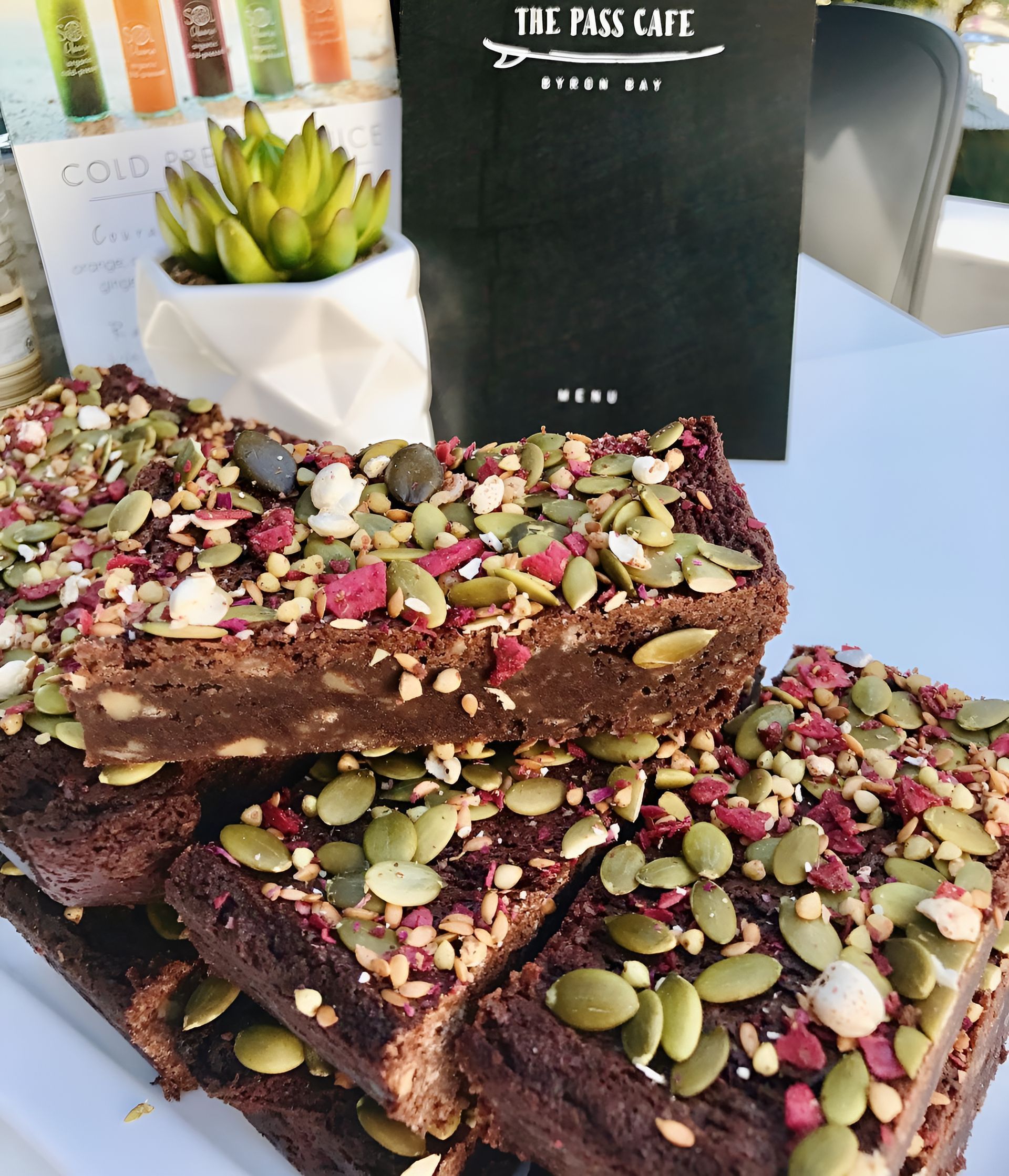 A Stack of Brownies With Pumpkin Seeds on Top of Them — The Pass Cafe In Byron Bay, NSW