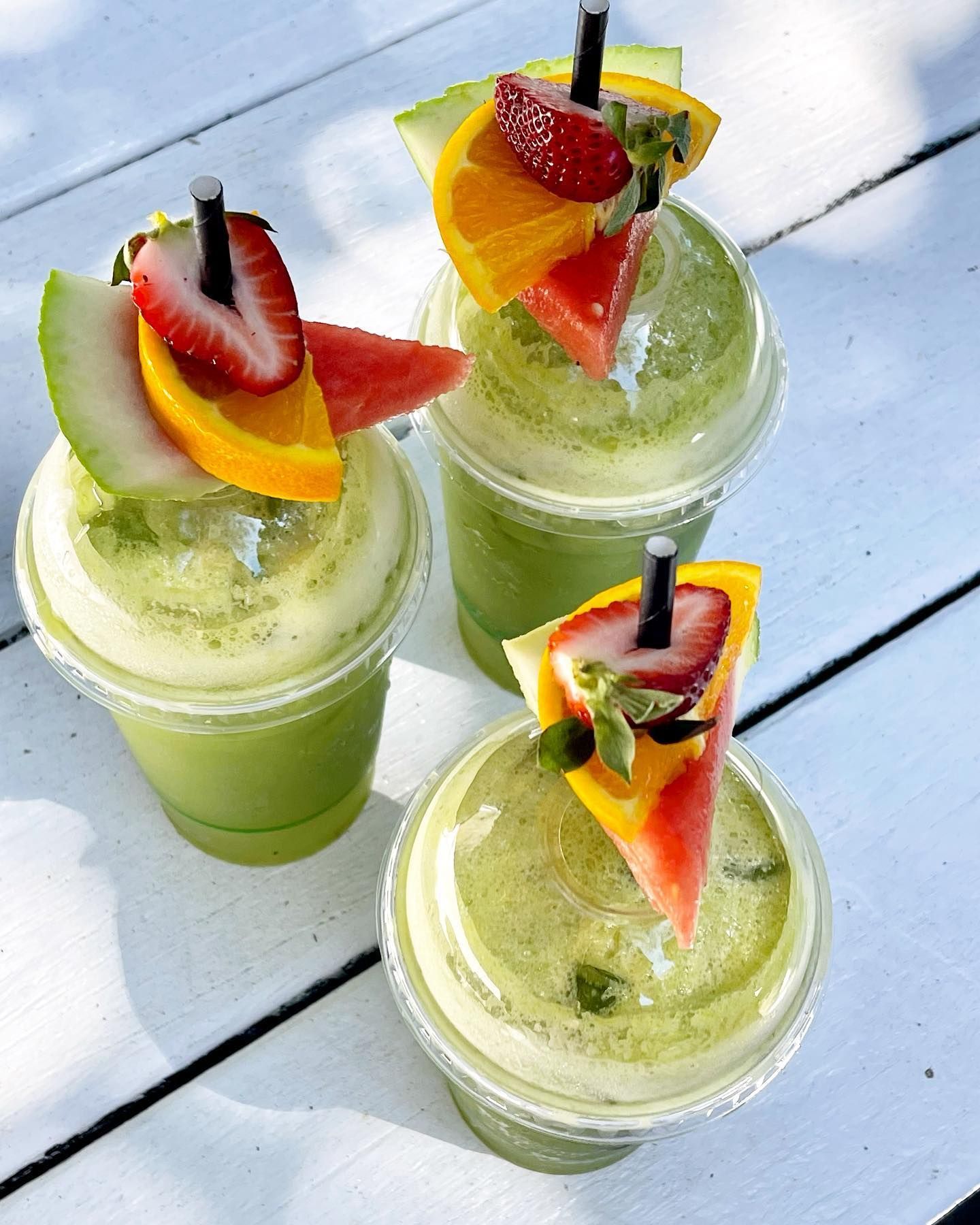 Three Cups of Green Smoothies With Fruit on Top — The Pass Cafe in Byron Bay, NSW