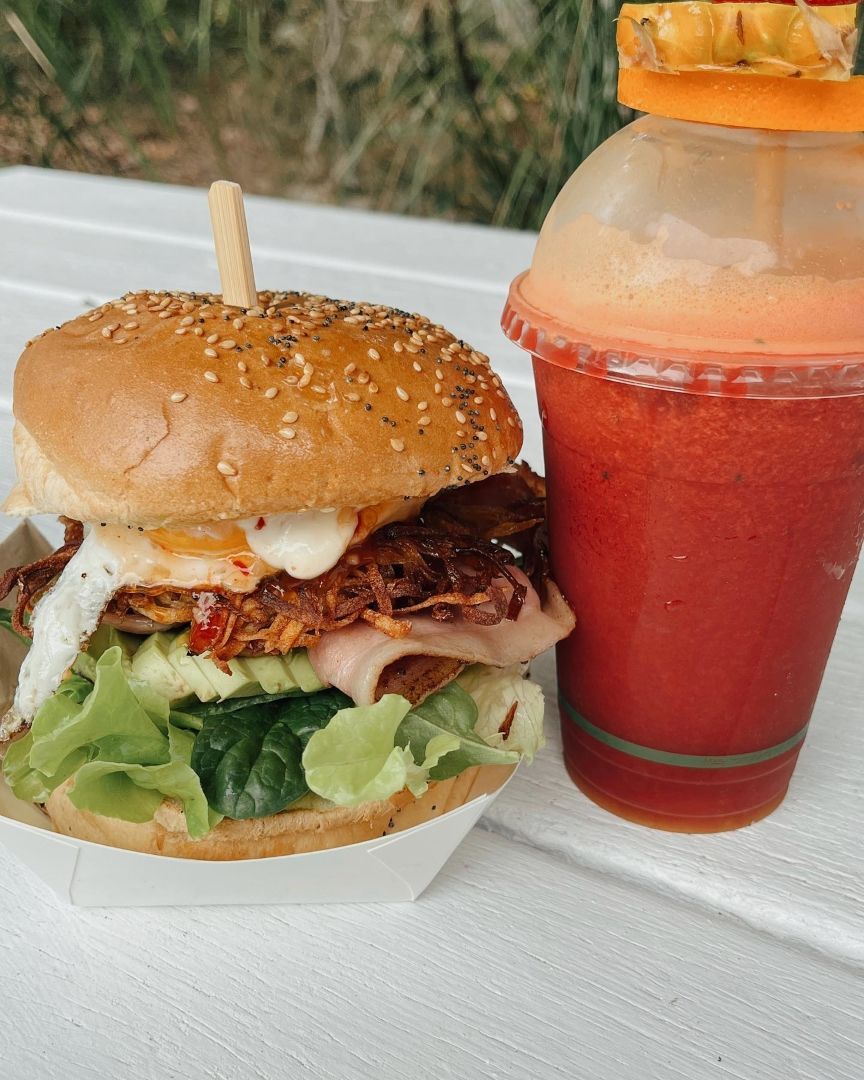 A Hamburger and a Smoothie Are on a Table — The Pass Cafe in Byron Bay, NSW