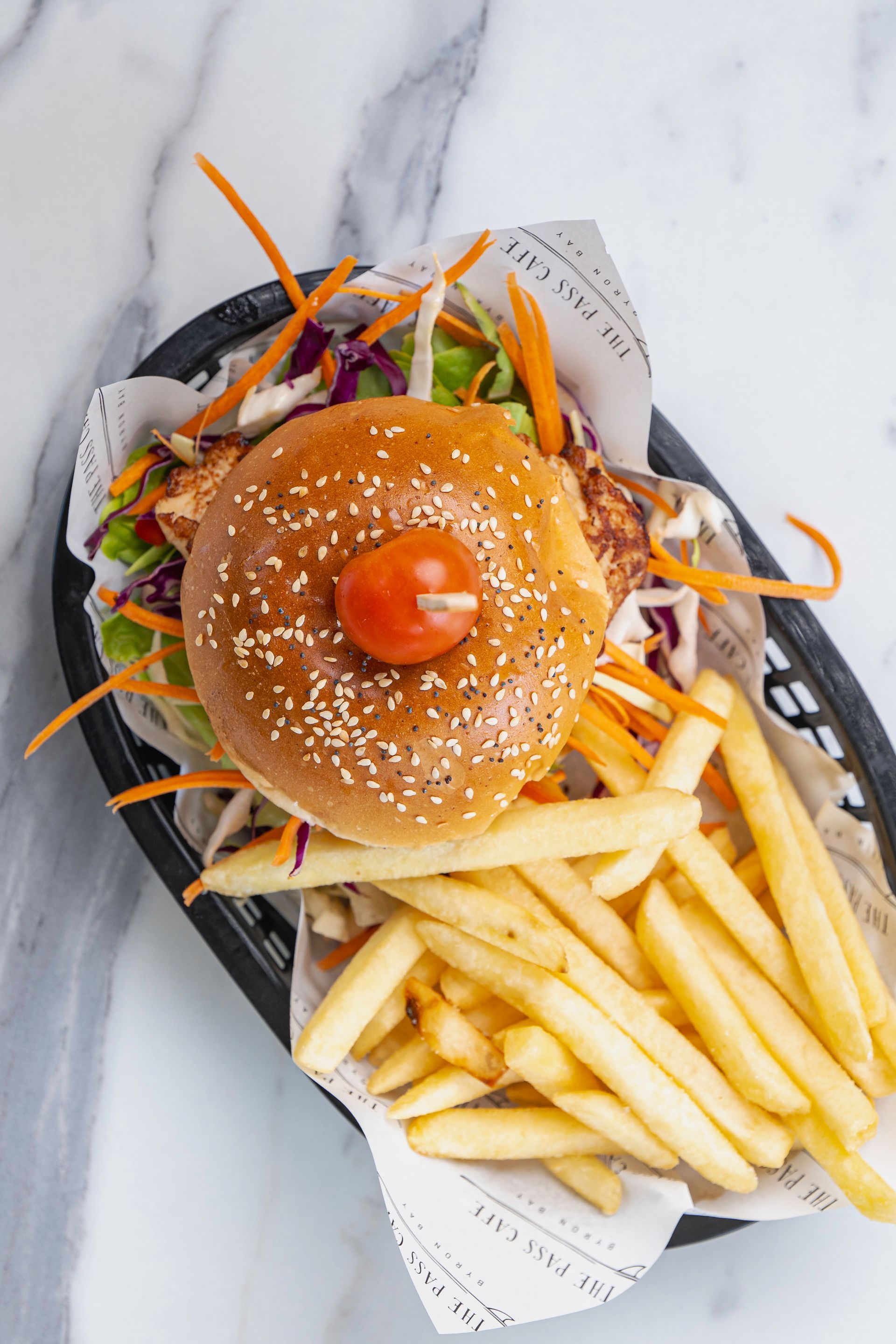 A Hamburger and French Fries in a Basket on a Table — The Pass Cafe In Byron Bay, NSW