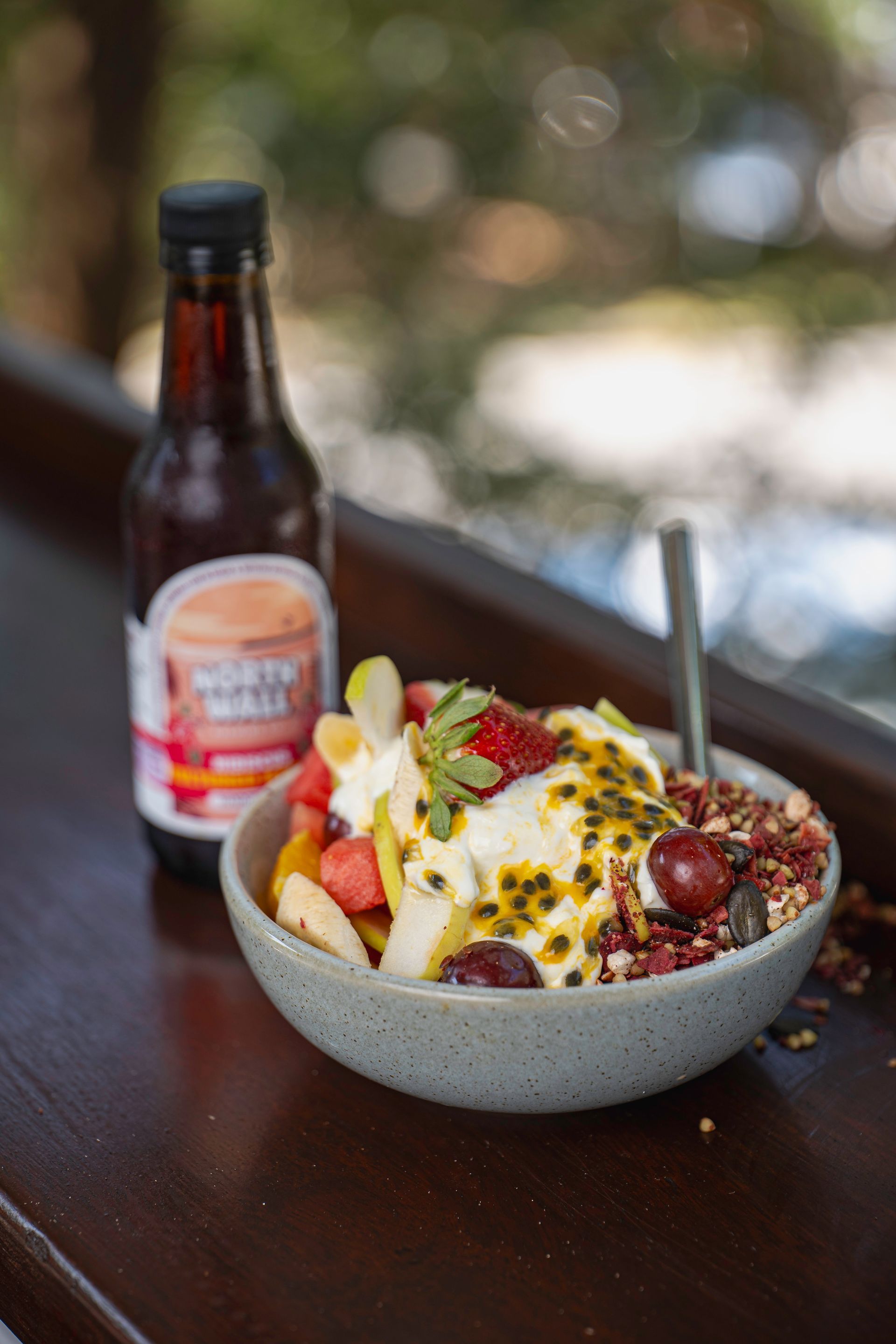 A Nourish Bowl Next to a Bottle of North Wall Probiotic — The Pass Cafe in Byron Bay, NSW