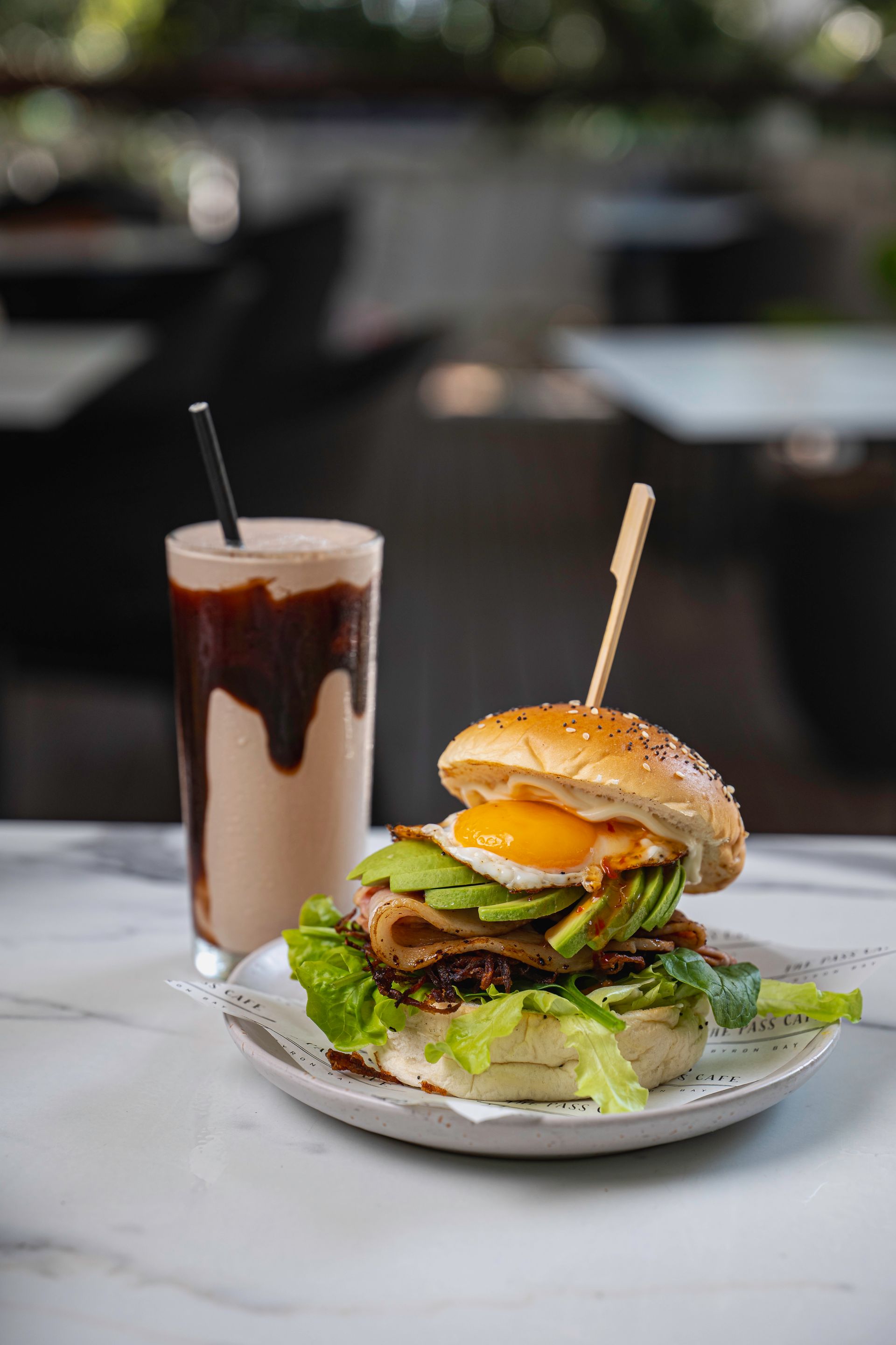 A Hamburger and a Milkshake Are on a Plate on a Table — The Pass Cafe In Byron Bay, NSW