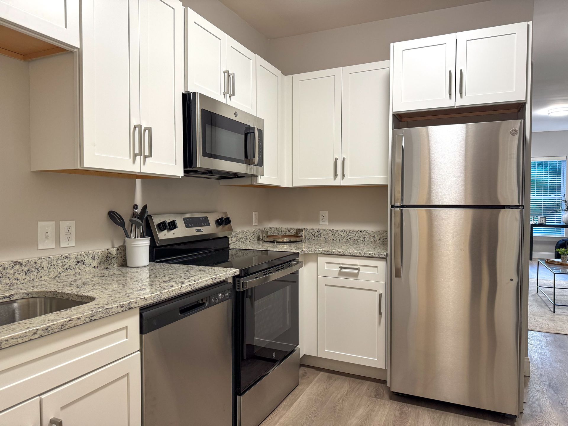 Kitchen with white cabinets, stainless steel appliances, and granite countertops.
