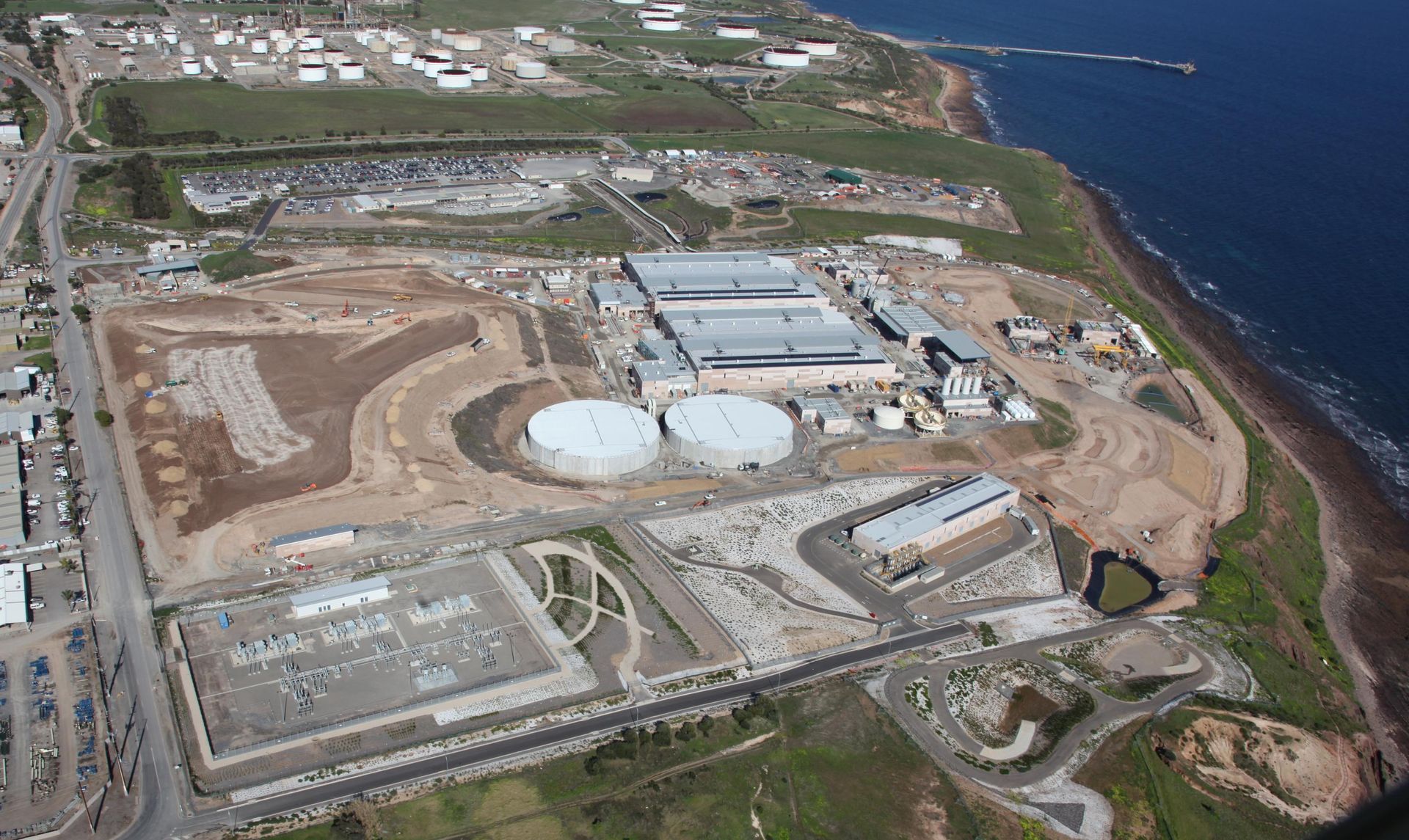An aerial view of a large industrial area next to the ocean