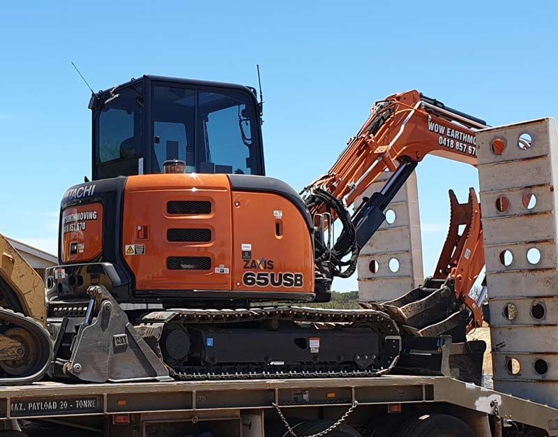 An excavator is sitting on top of a trailer.