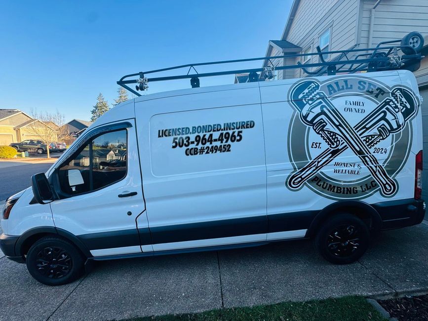A white plumbing van parked in a driveway with