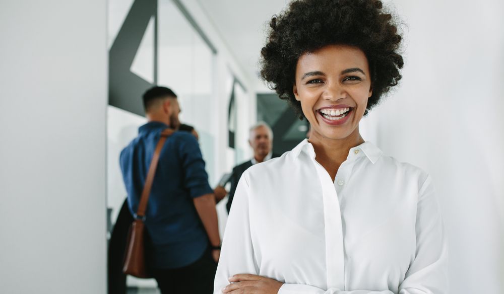 Woman looking at camera and smiling with her team