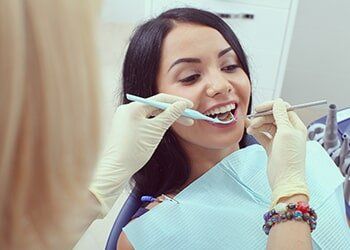 Female Dentist Cleaning Female Patient Teeth—Dentists in Whittier, NC