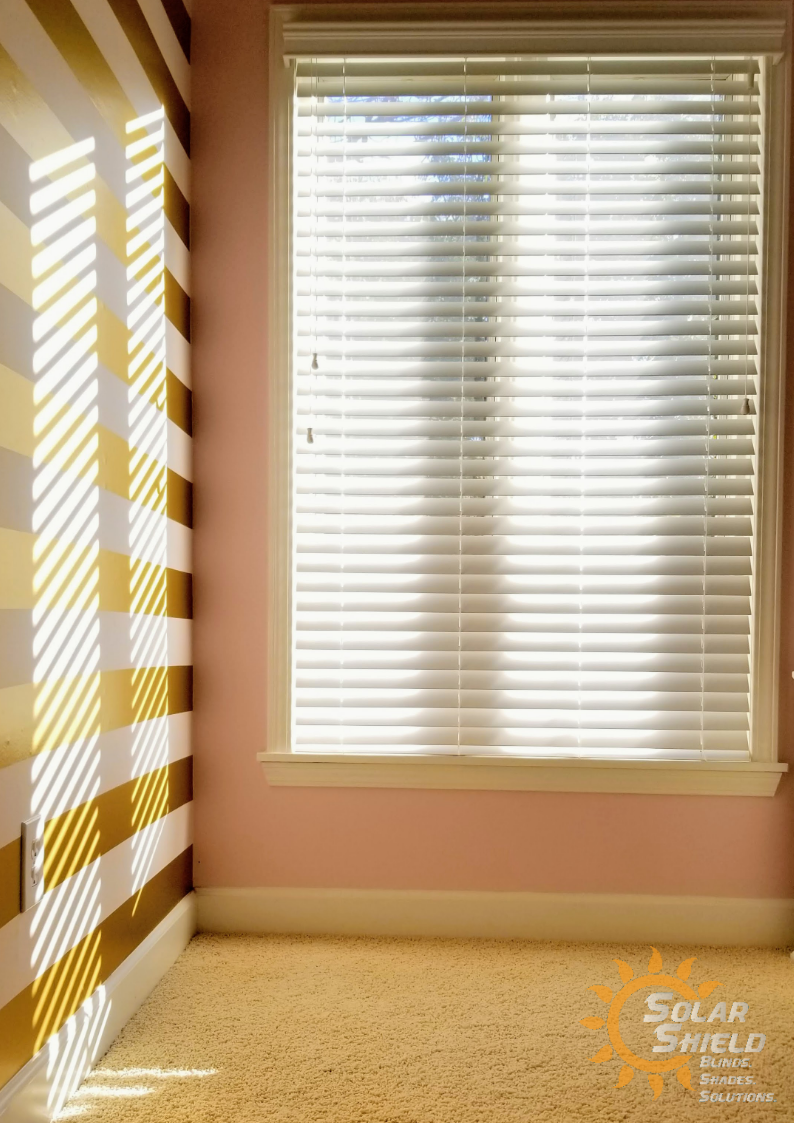 A room with a striped wall and a window with blinds
