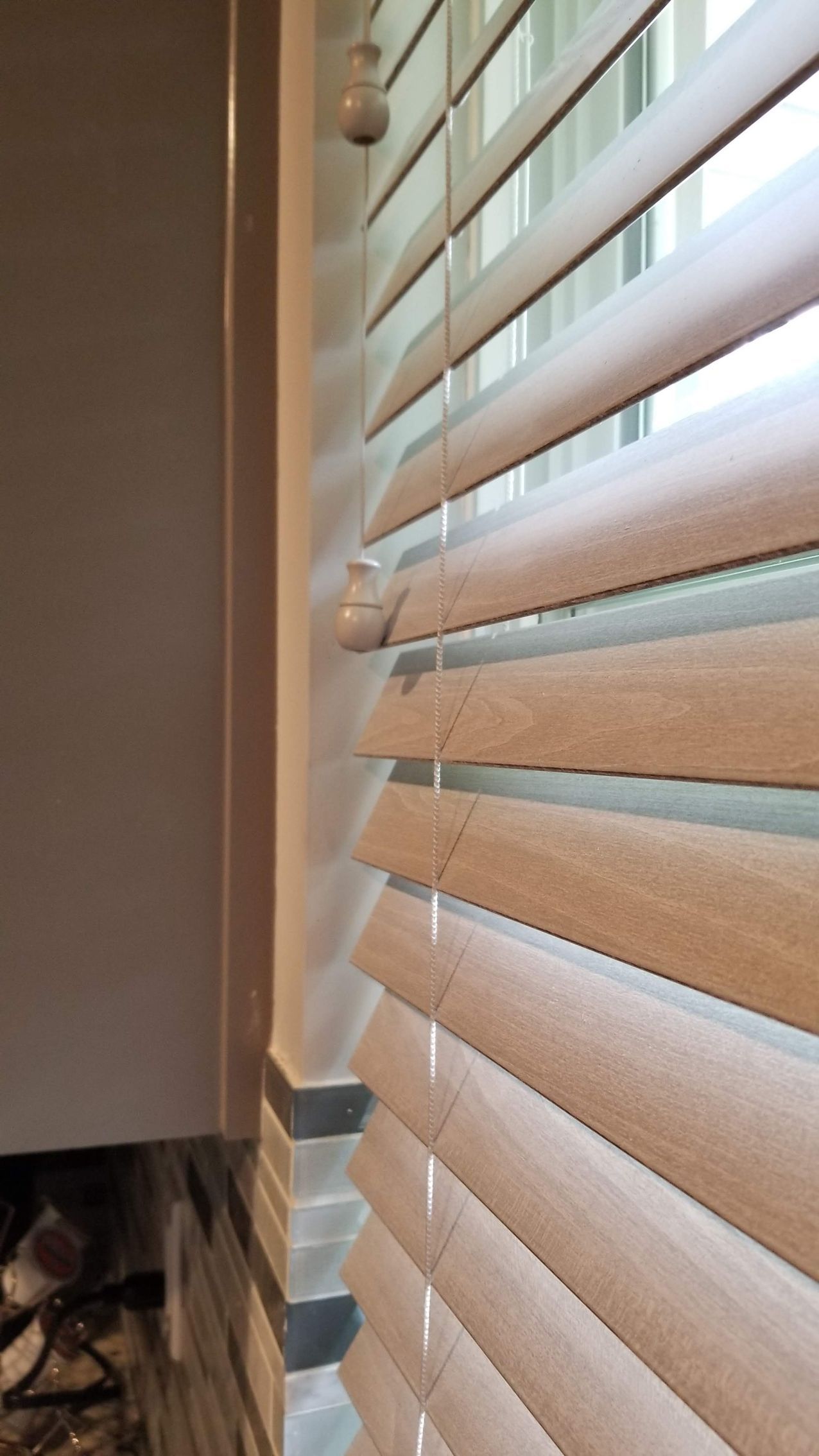 A close up of a window with wooden blinds on it.