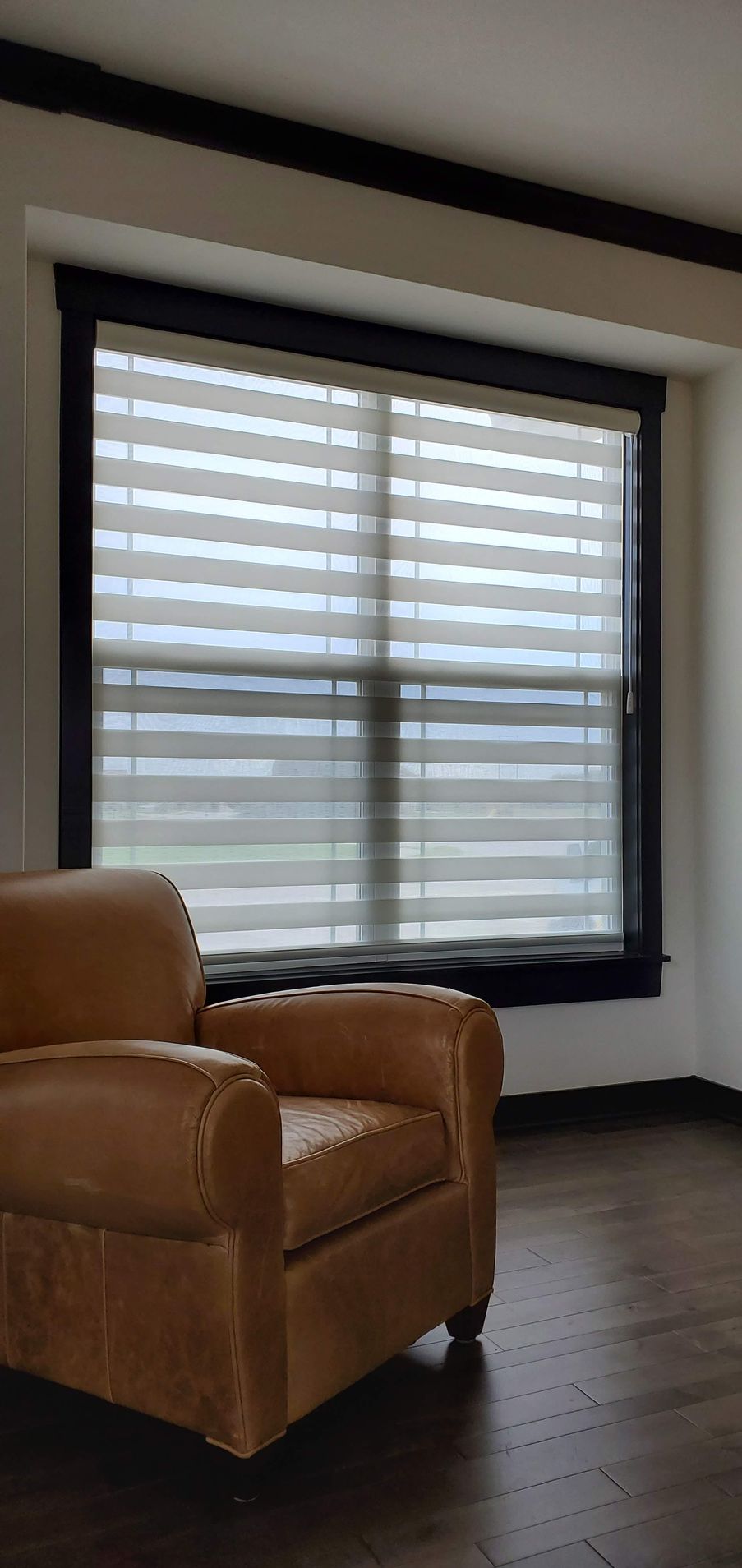 Sitting room with Solar Shield Banded Shades installed on window.
