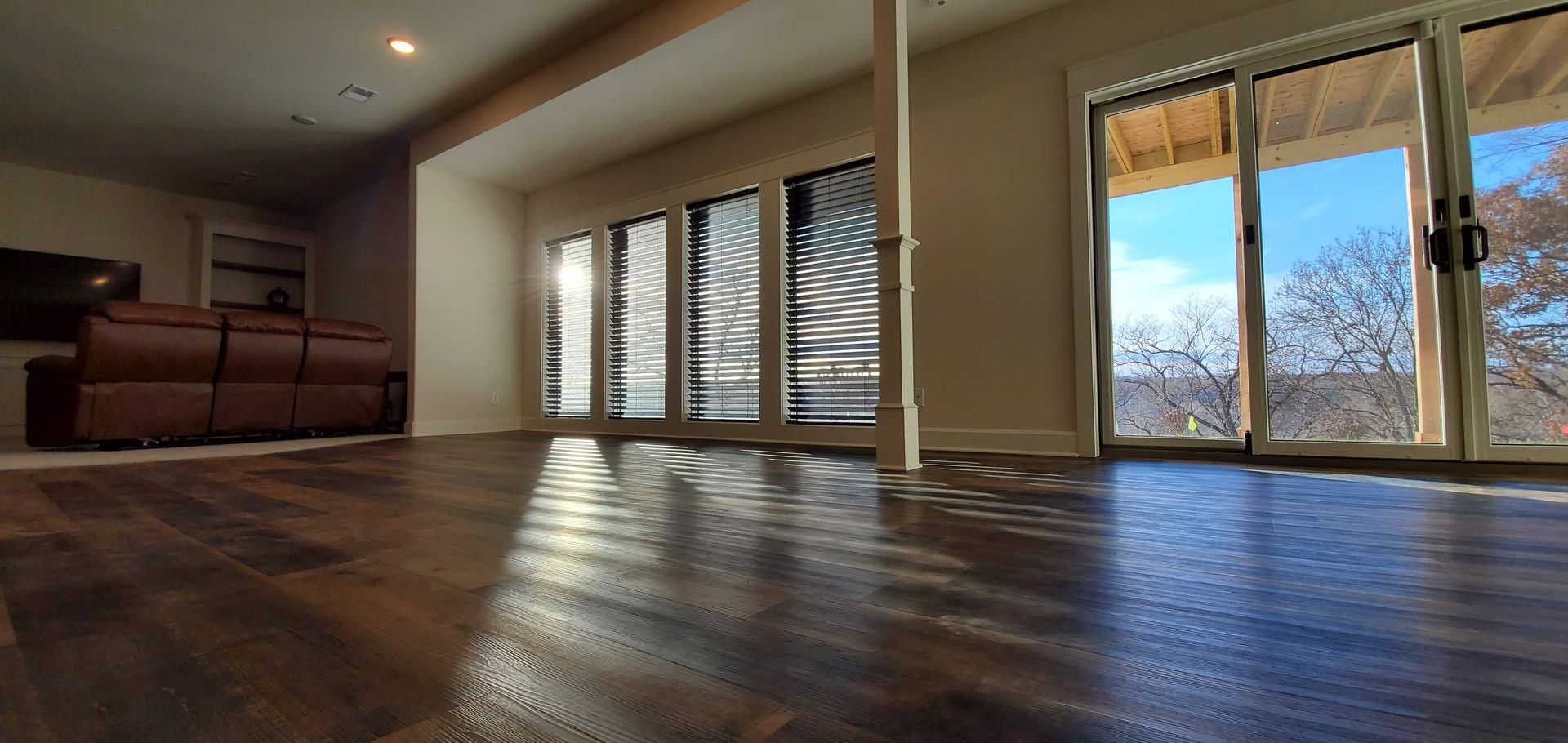 A living room with hardwood floors and sliding glass doors.