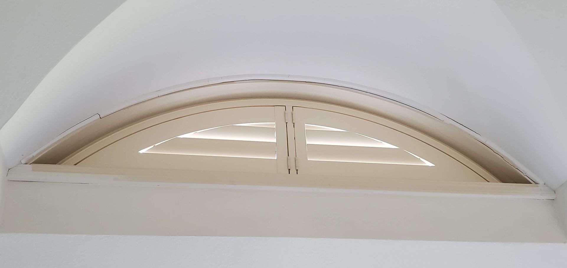 Solar Shield Arched Shutter for specialty shaped window installed in a master bedroom arched window