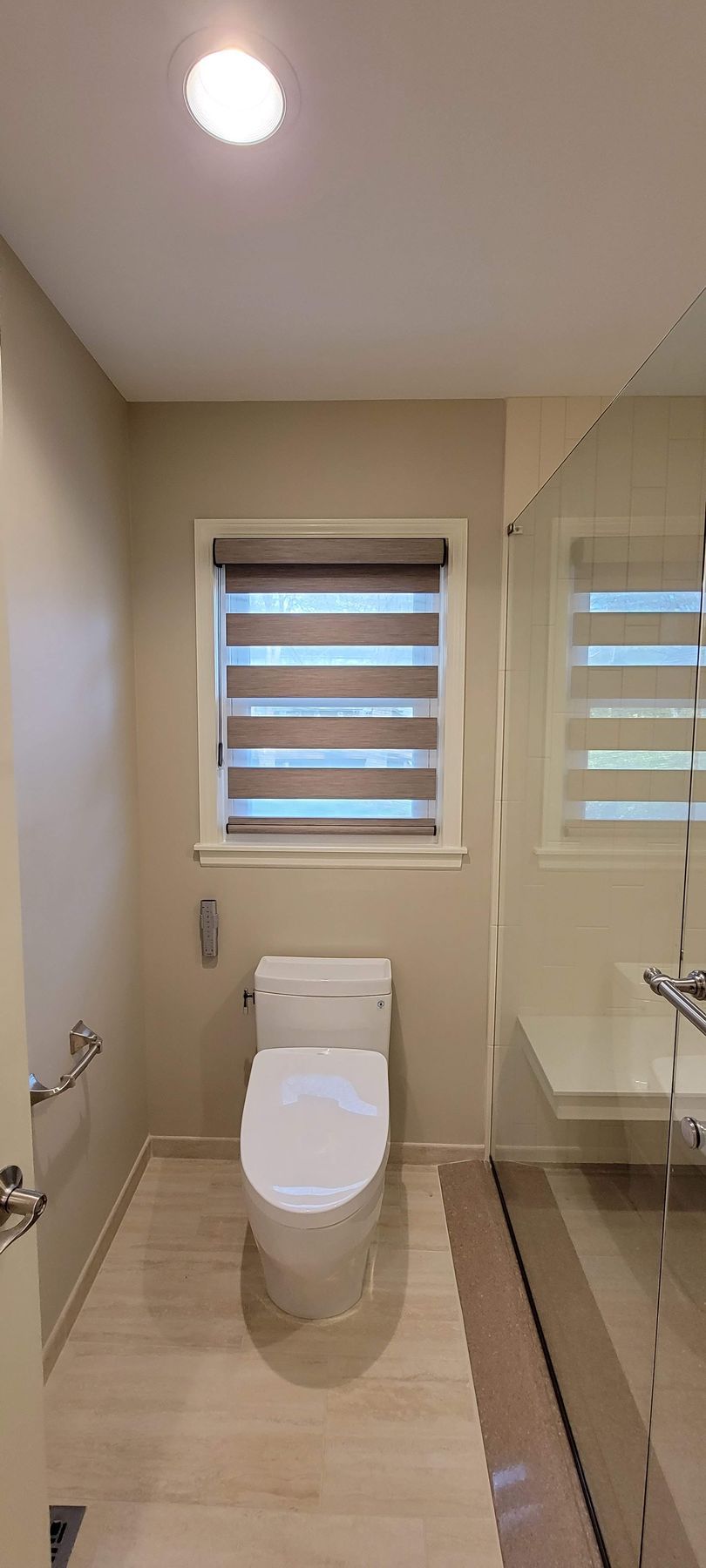 Solar Shield Banded Shades hanging in bathroom window over toilet