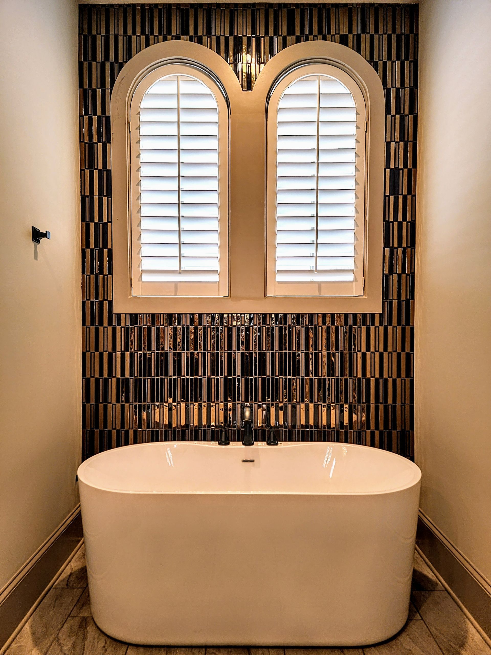 Arched Solar Shield Shutters installed over a bathtub