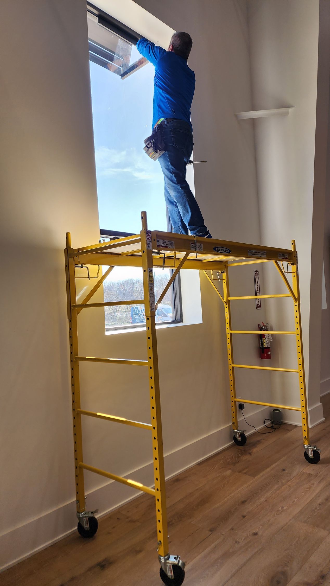 Solar Shield installer installing commercial roller shades in Kansas City building