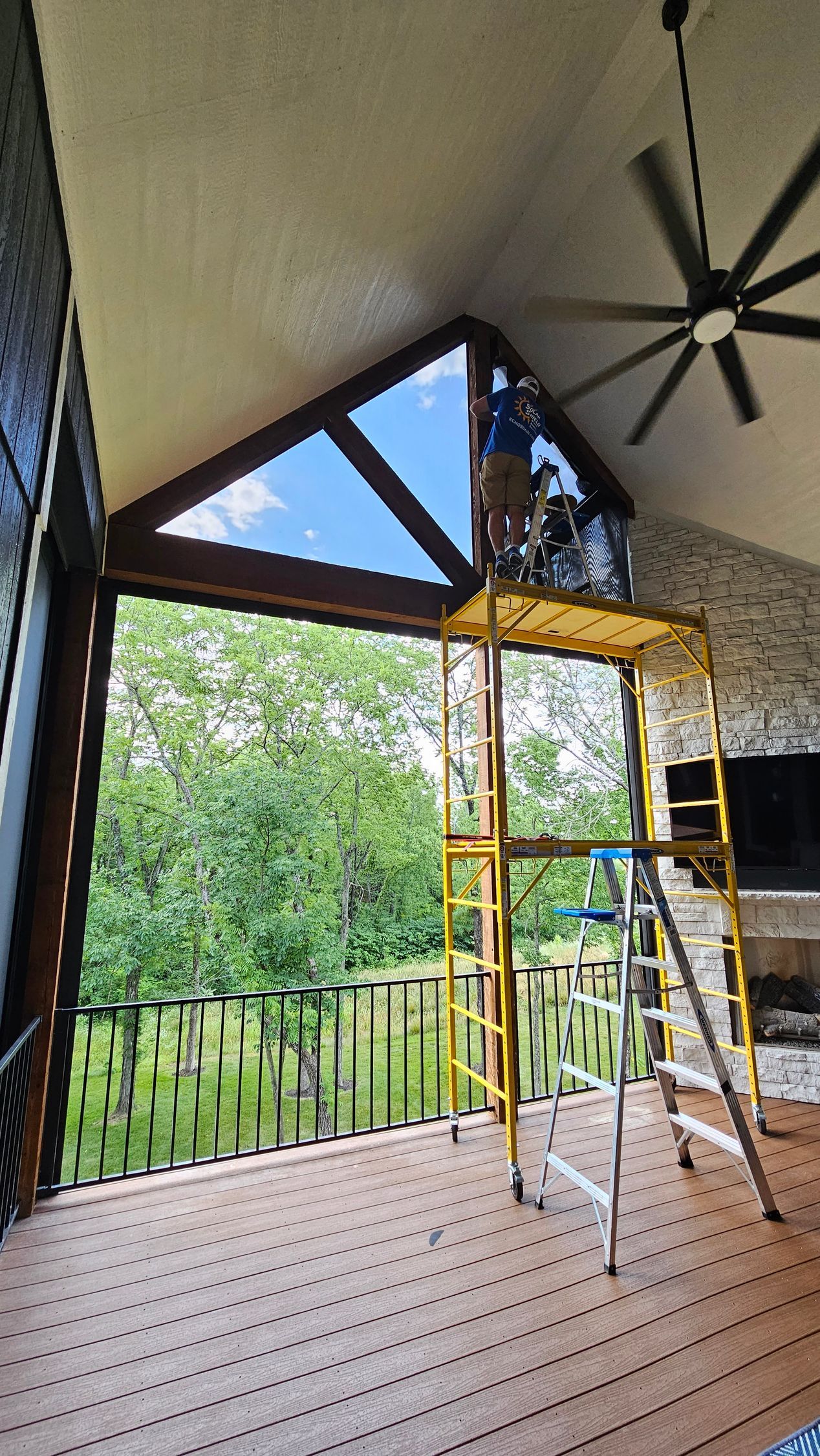 Solar Shield installer putting in fixed screens on patio on top of scaffolding