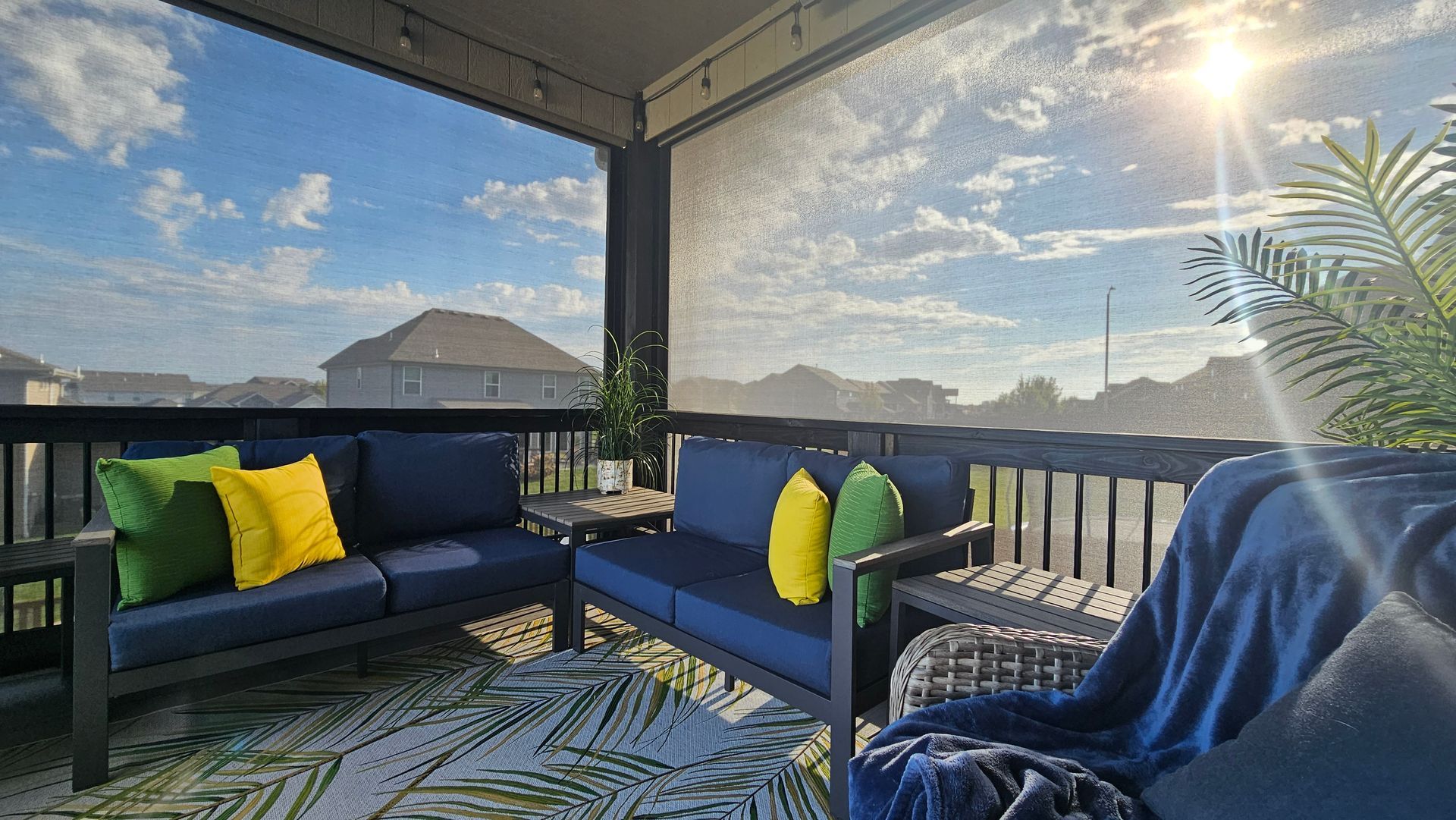 A patio with a couch , chair , table and rug.