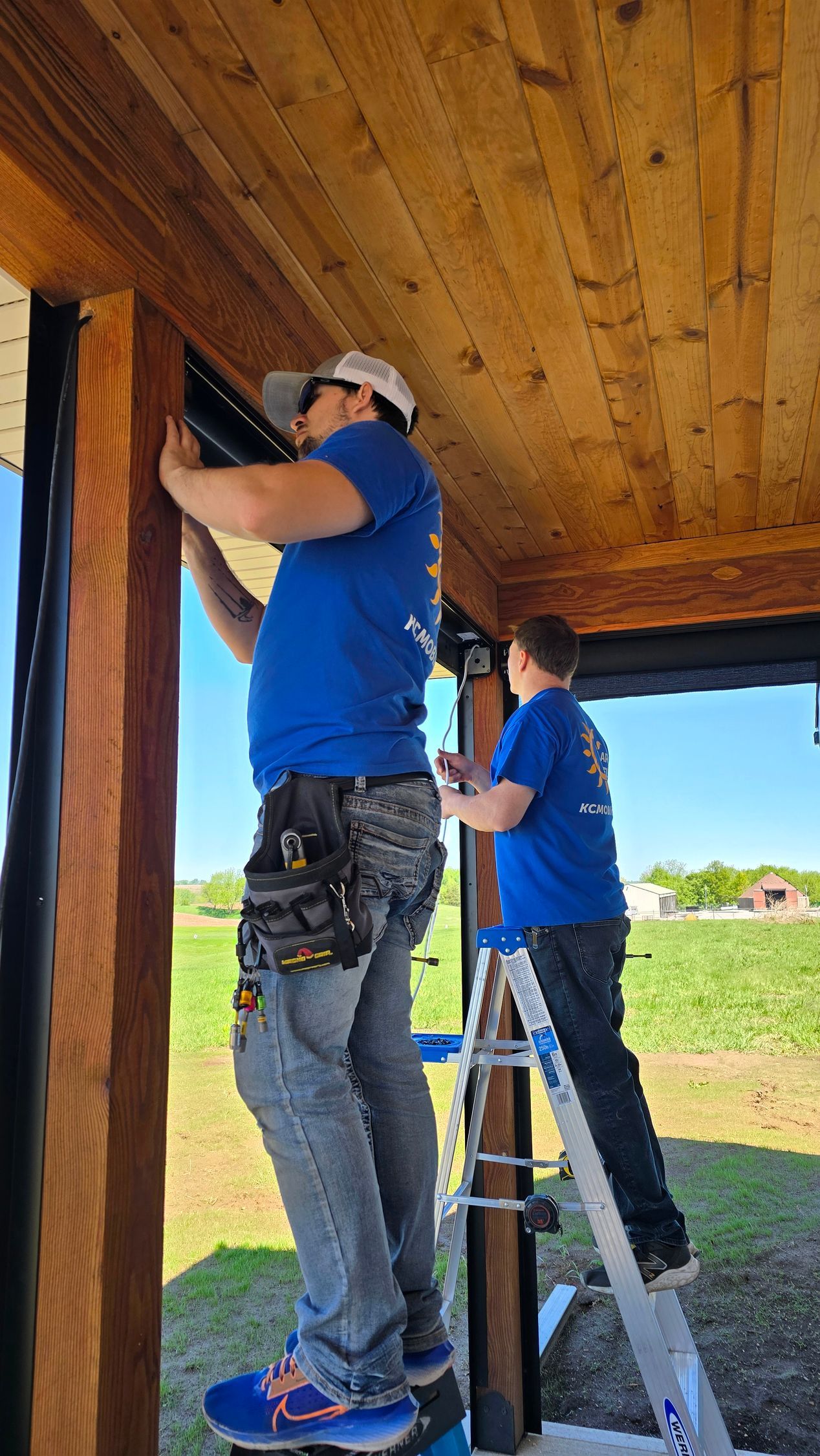 Solar Shield installers working on exterior patio shades