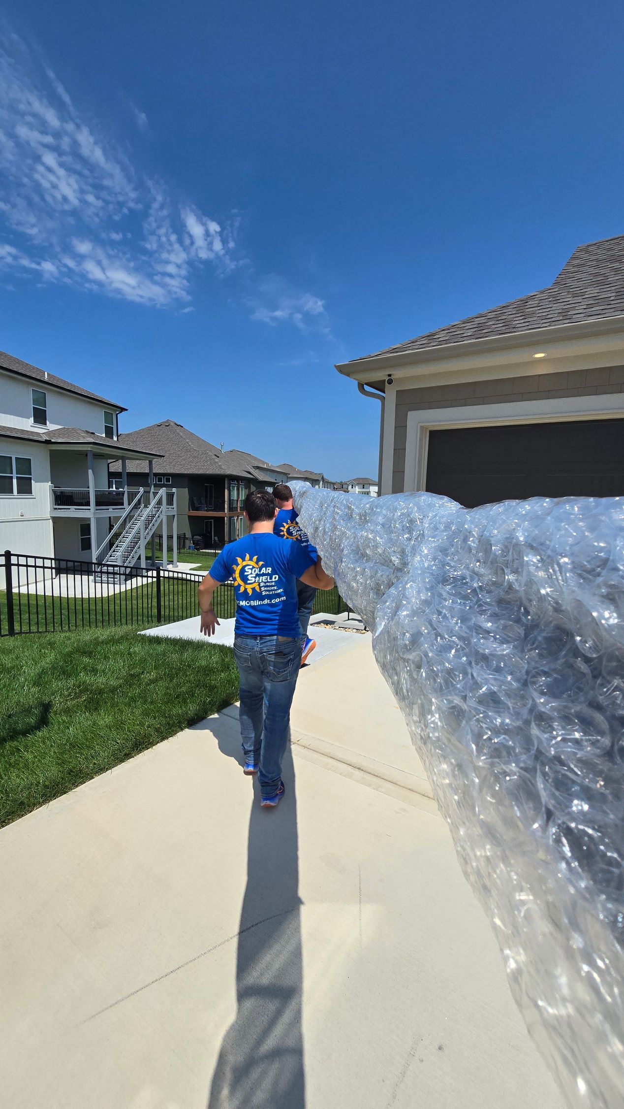 Solar Shield install team carrying a large outdoor retractable awning