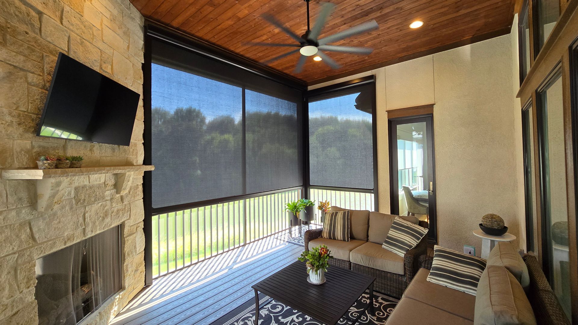 patio shades partially opened showing bug screen behind on a patio in the summer