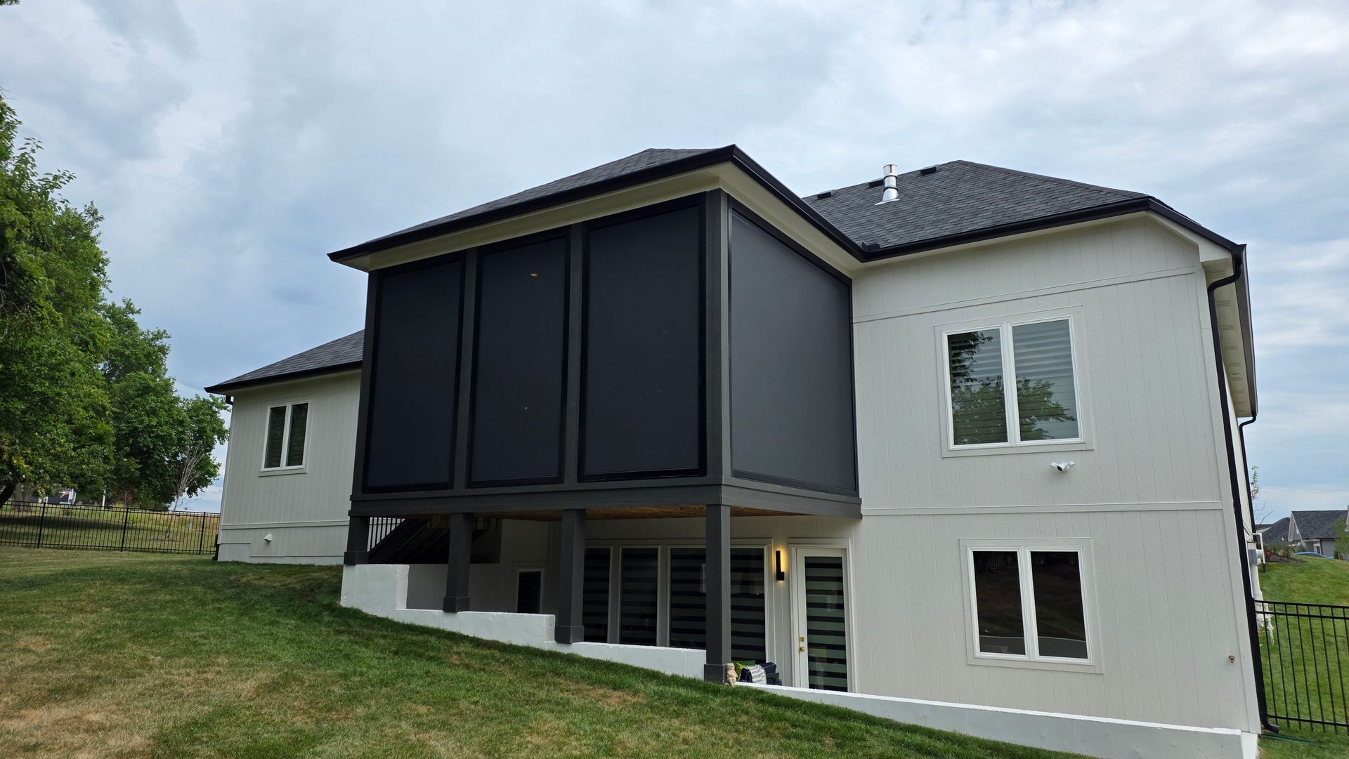 Solar Shield Patio Shades installed on a deck on a white house