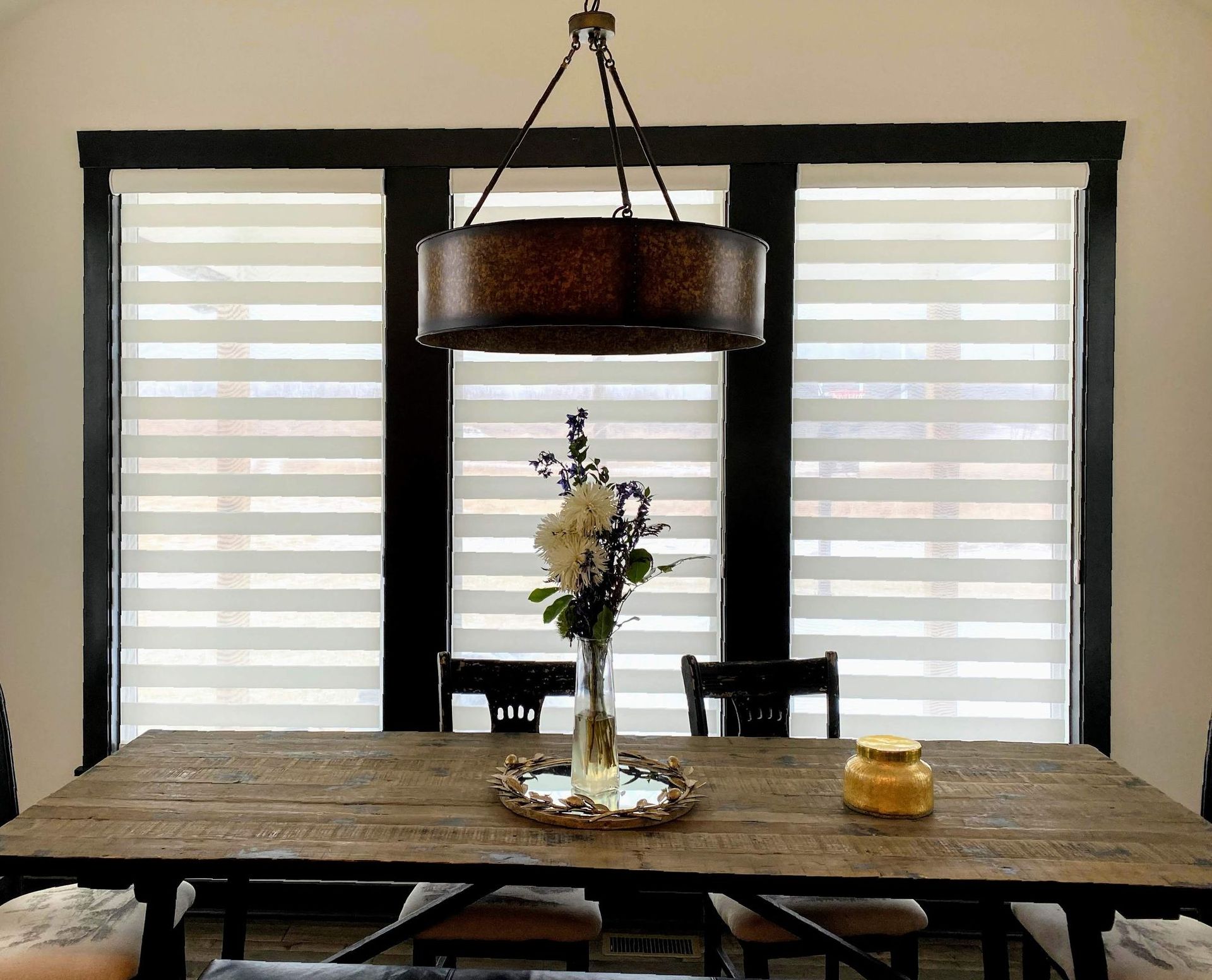 A kitchen with a window and a cutting board on the counter.