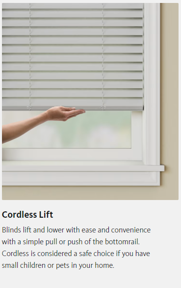 A person is holding a cordless lift blind in a window.