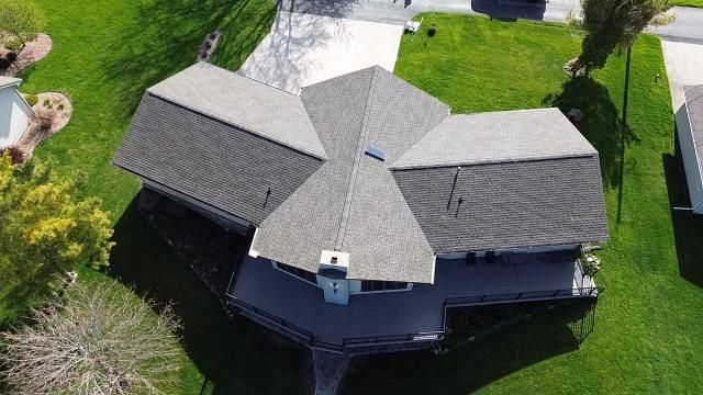 A man is standing on a ladder on the side of a building.