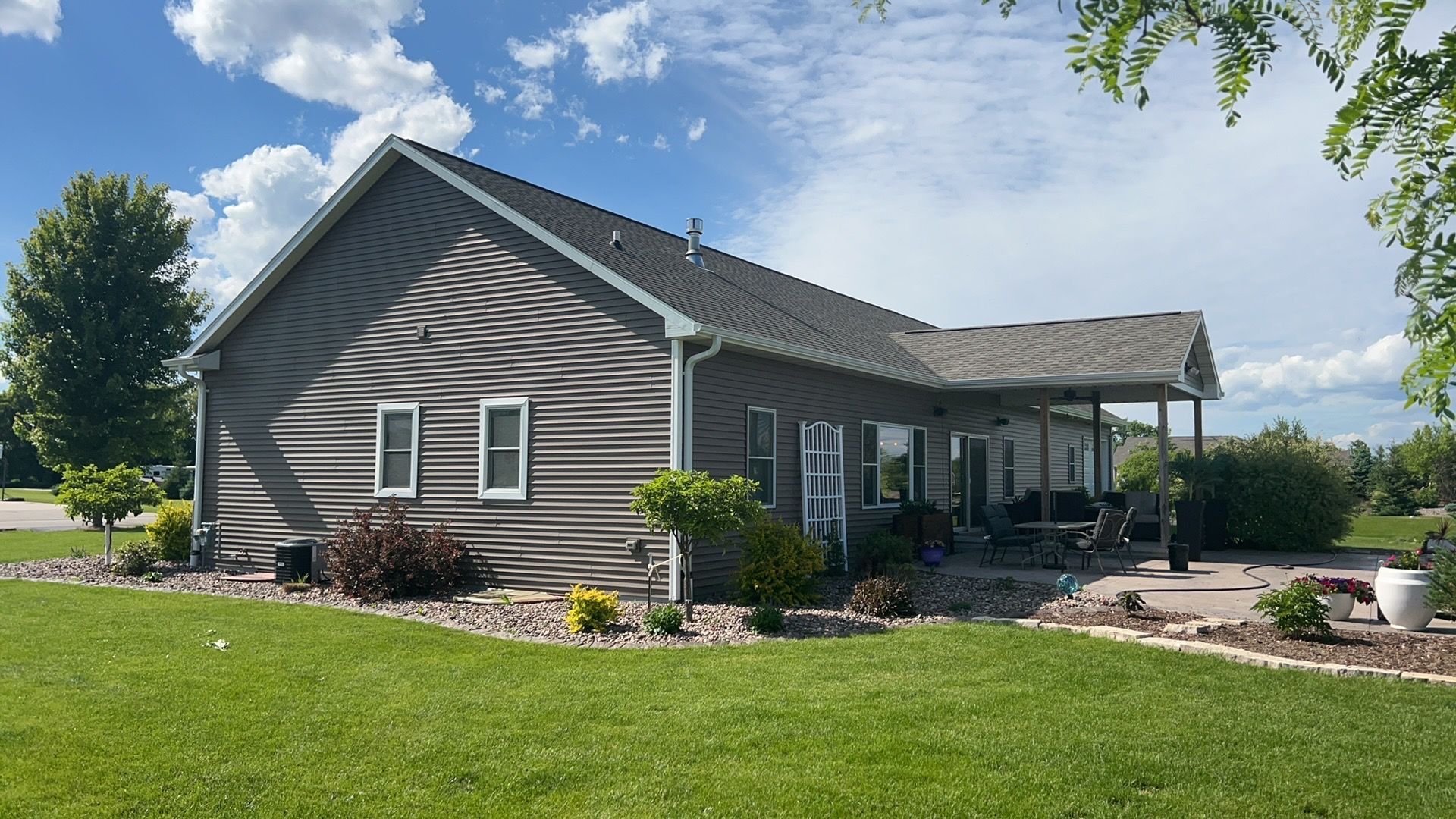 A large house with a lot of windows is sitting on top of a lush green field.