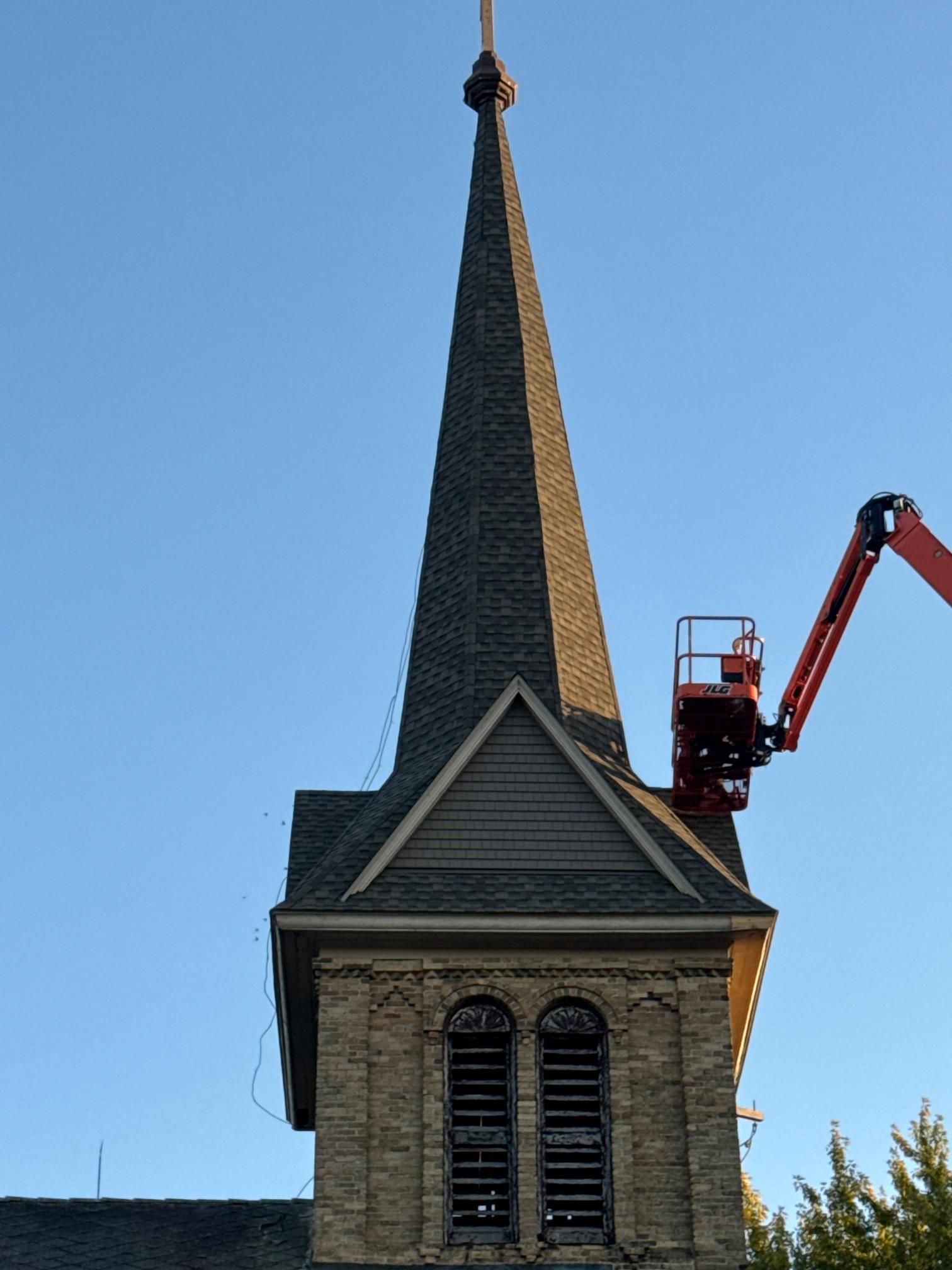 A large house with a lot of windows is sitting on top of a lush green field.